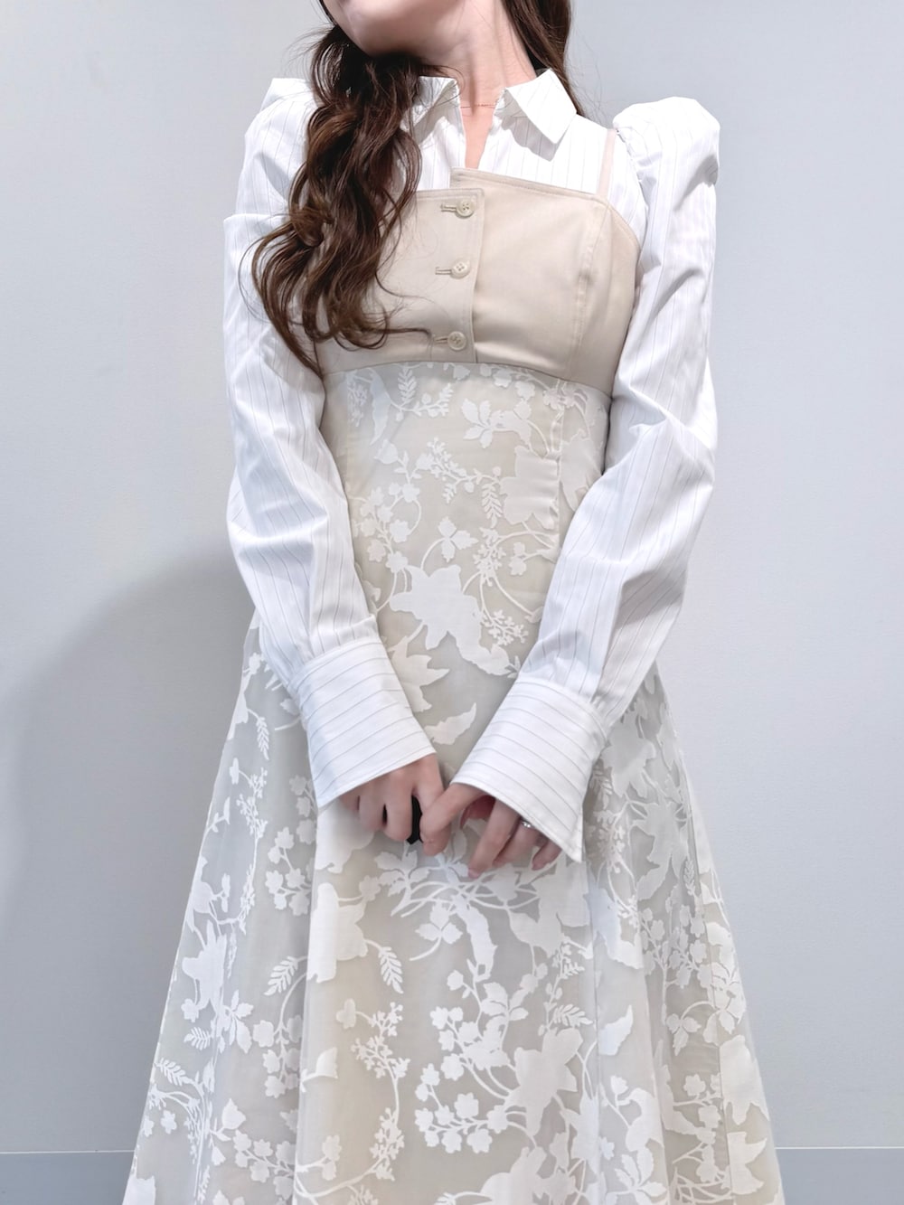 ベージュ系のワンピース、ホワイト系のパンプスを着用したレディースの冬コーディネートの5枚目の写真