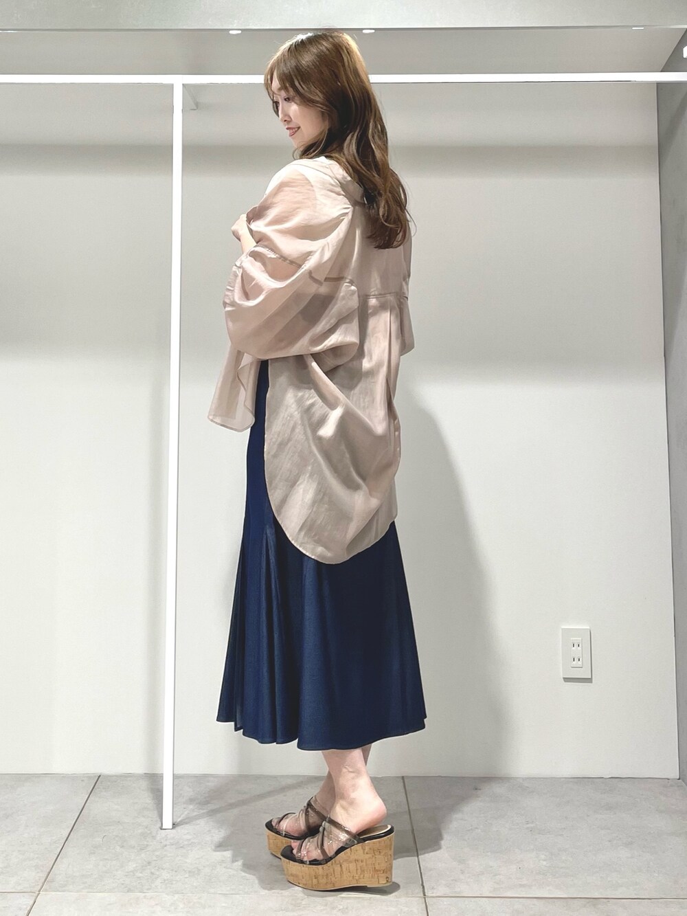 ブルー系のスカート、ブラック系のサンダル、ベージュ系のシャツ/ブラウスを着用したレディースの春コーディネートの2枚目の写真