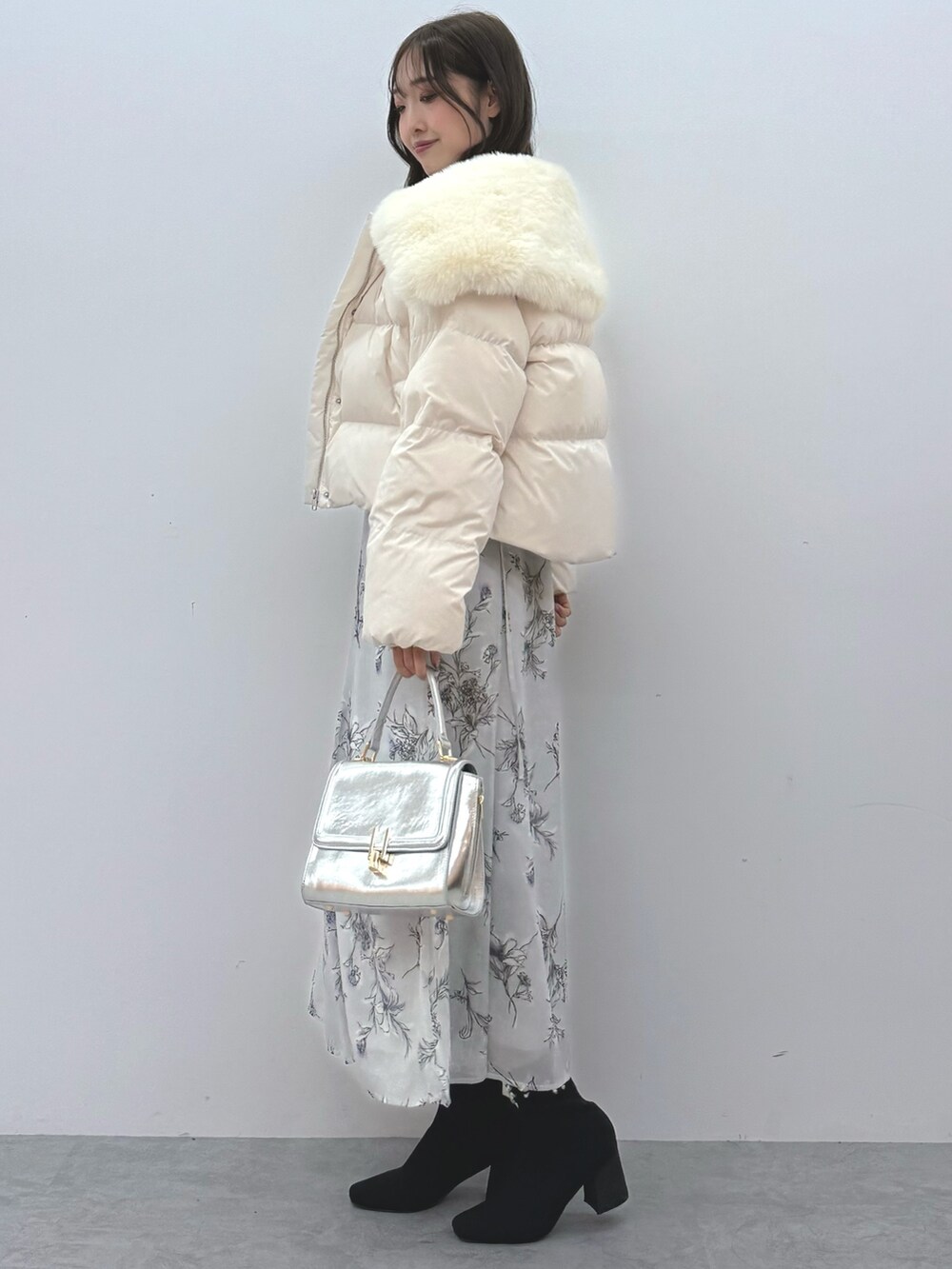 ホワイト系のダウンジャケット/コート、シルバー系のハンドバッグ、ブラック系のブーツを着用したレディースの秋コーディネートの3枚目の写真