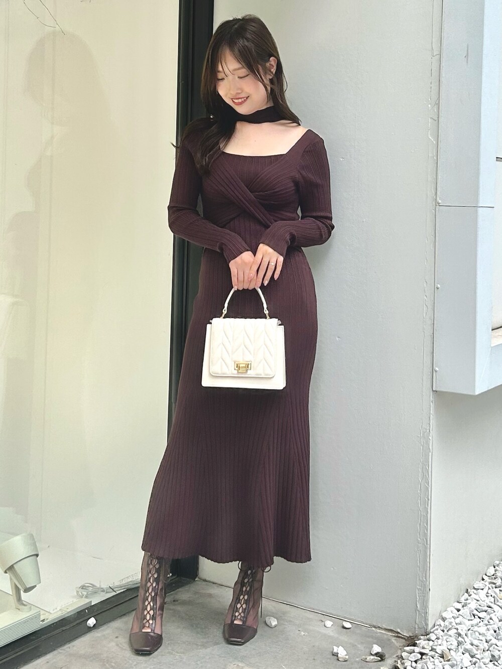 ホワイト系のライダースジャケット、ブラウン系のワンピース、ホワイト系のショルダーバッグを着用したレディースの夏コーディネートの4枚目の写真