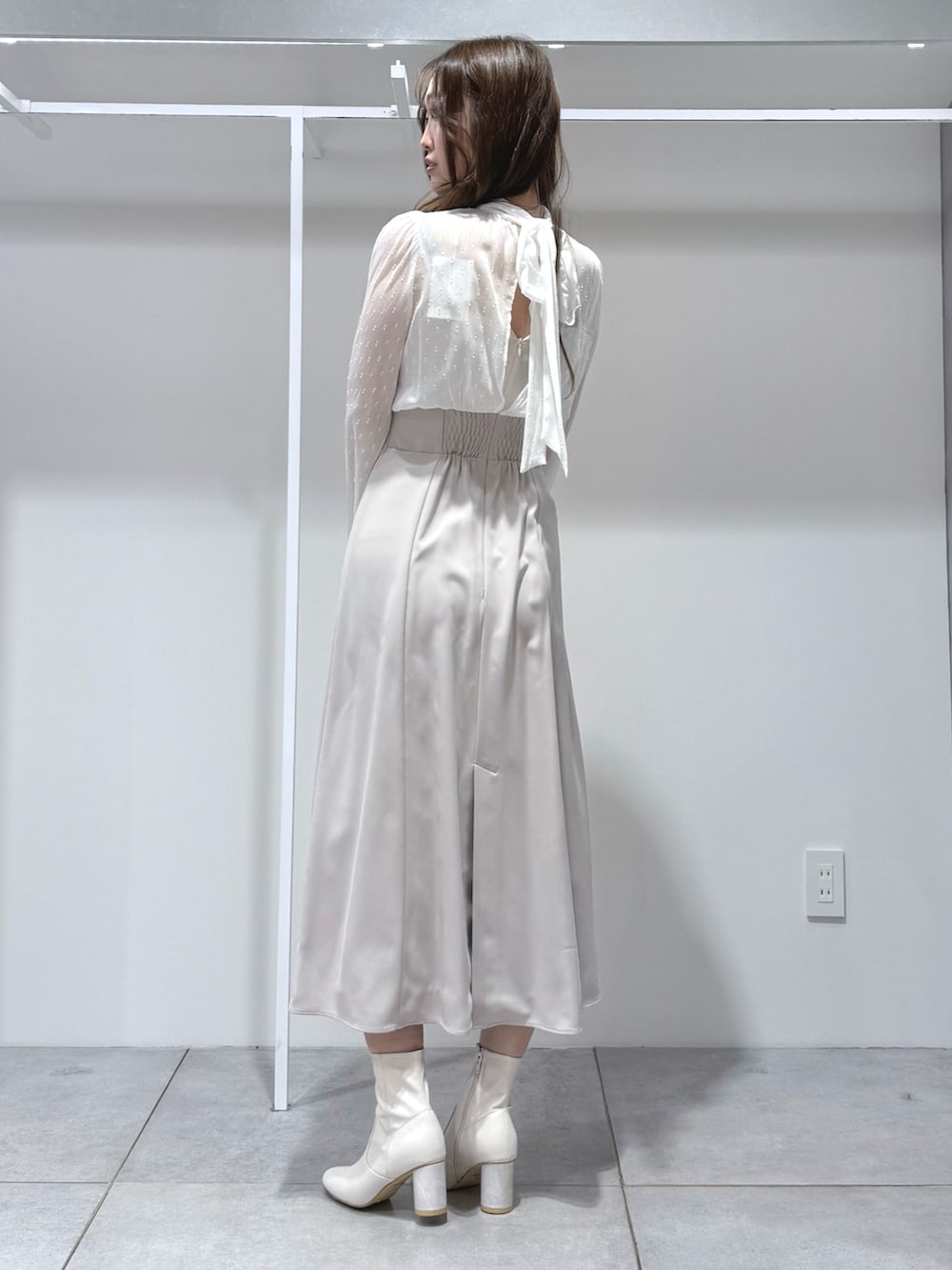 ホワイト系のワンピース、ホワイト系のブーツを着用したレディースの冬コーディネートの3枚目の写真