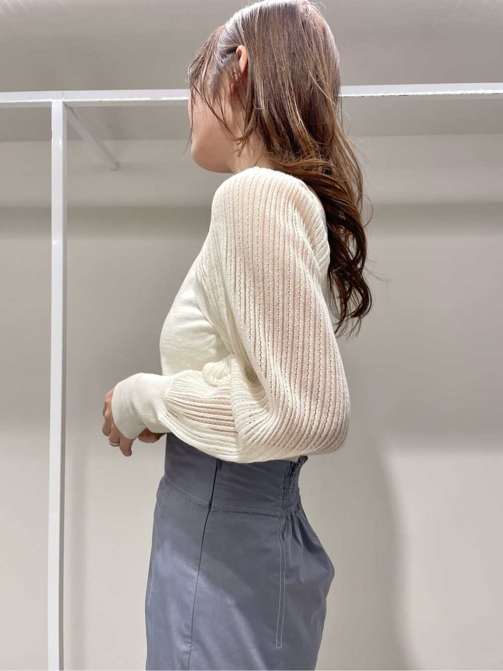 ブルー系のスカート、ホワイト系のニット/セーターを着用したレディースの春コーディネートの5枚目の写真