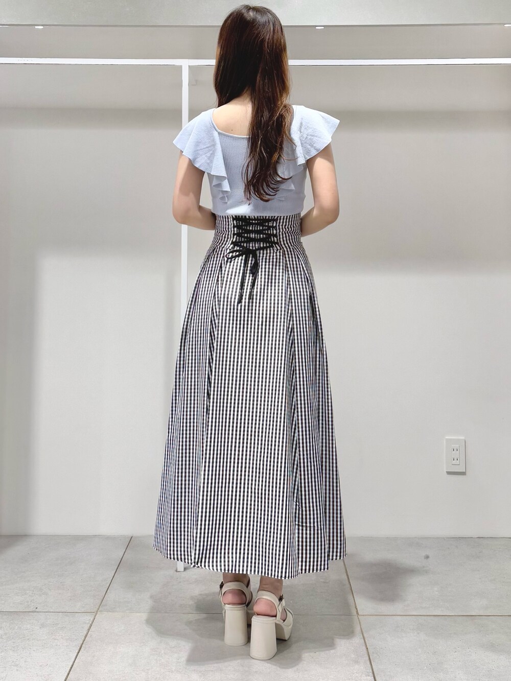 ブルー系のニット/セーター、その他のスカート、ホワイト系のサンダルを着用したレディースの春コーディネートの4枚目の写真