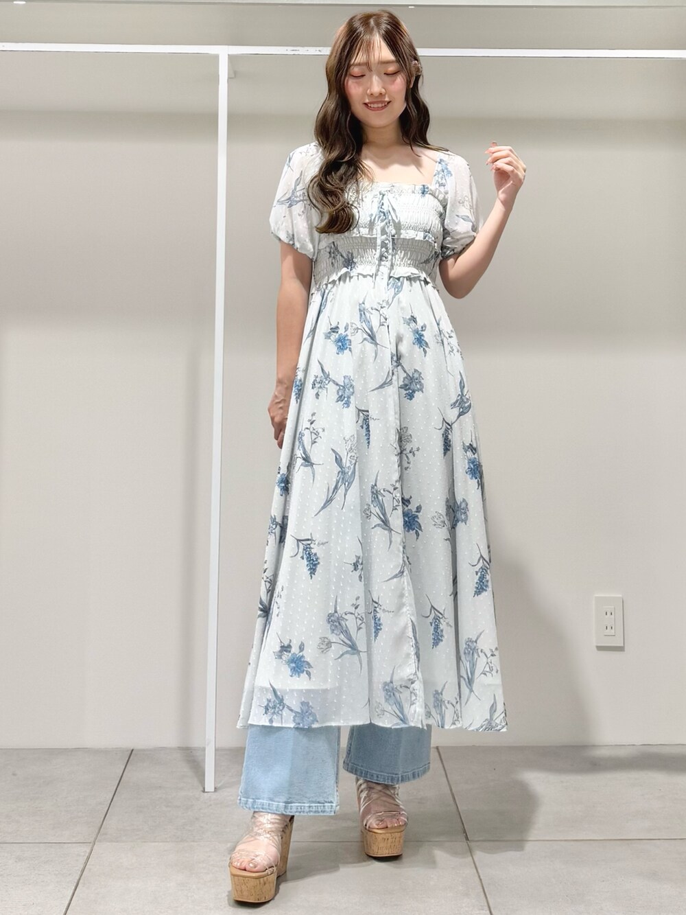 グレー系のワンピース、ブルー系のデニムパンツ、その他のサンダルを着用したレディースの春コーディネートの2枚目の写真