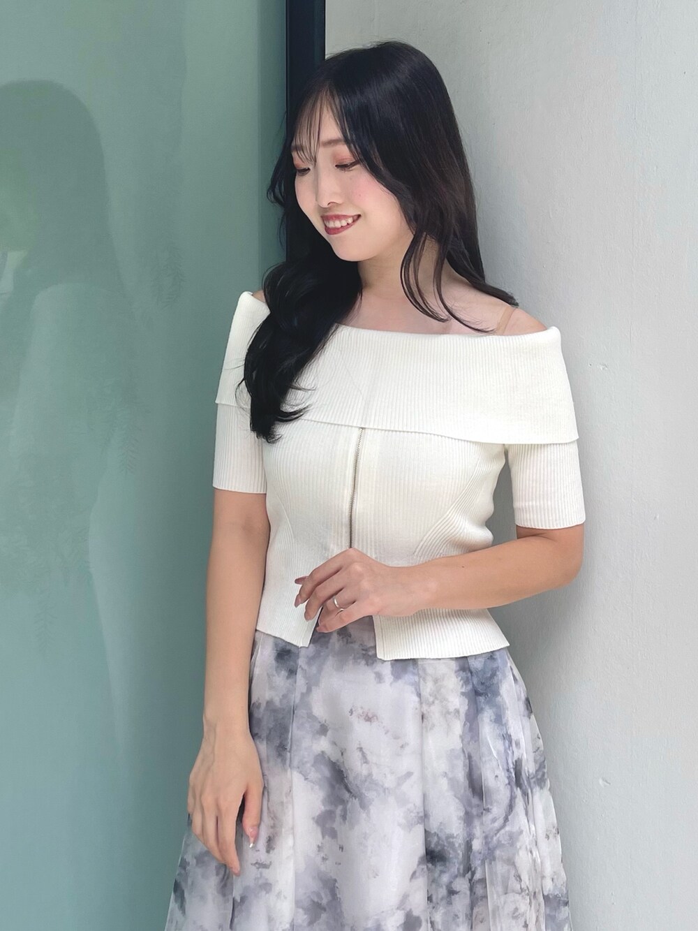 ホワイト系のニット/セーター、グレー系のスカート、ベージュ系のパンプスを着用したレディースの夏コーディネートの5枚目の写真