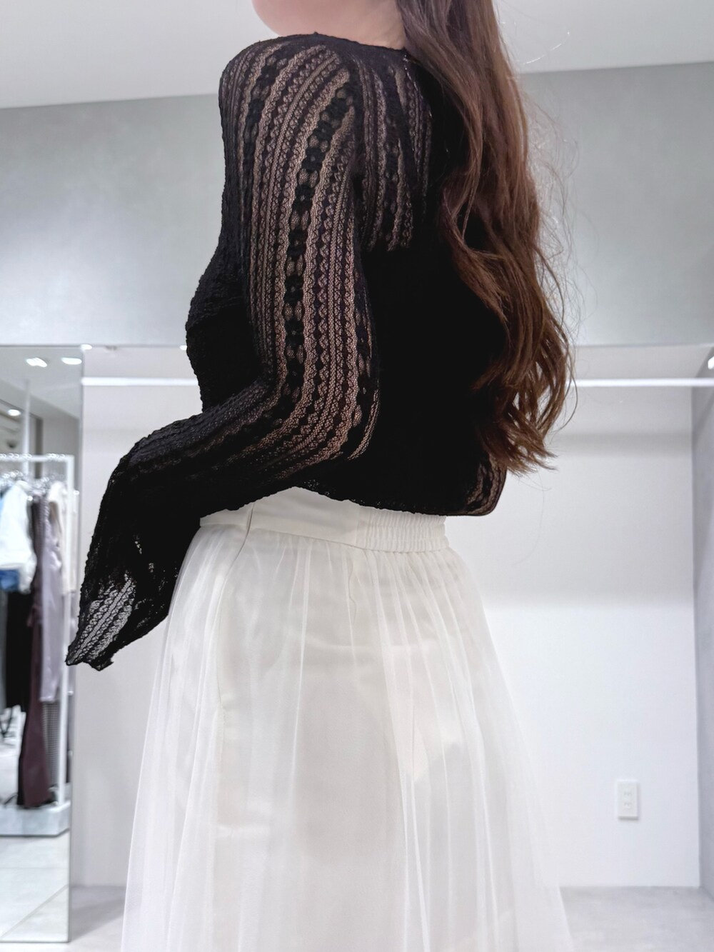 ブラック系のブーツ、ホワイト系のスカート、ブラック系のTシャツ/カットソーを着用したレディースの秋コーディネートの6枚目の写真