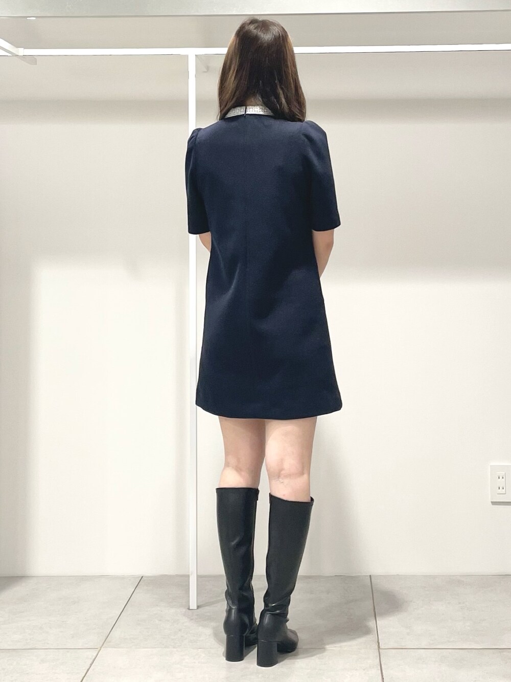 ブルー系のワンピース、ブラック系のブーツ、グレー系のハンドバッグを着用したレディースの秋コーディネートの4枚目の写真