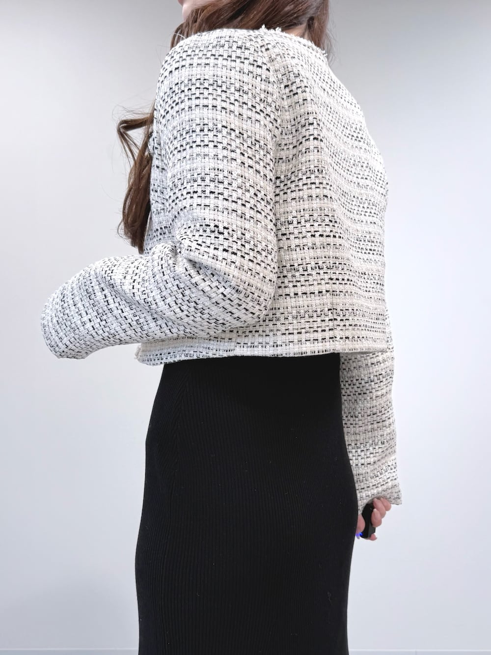 ホワイト系のテーラードジャケット、ブラック系のワンピース、ブラック系のブーツを着用したレディースの冬コーディネートの5枚目の写真