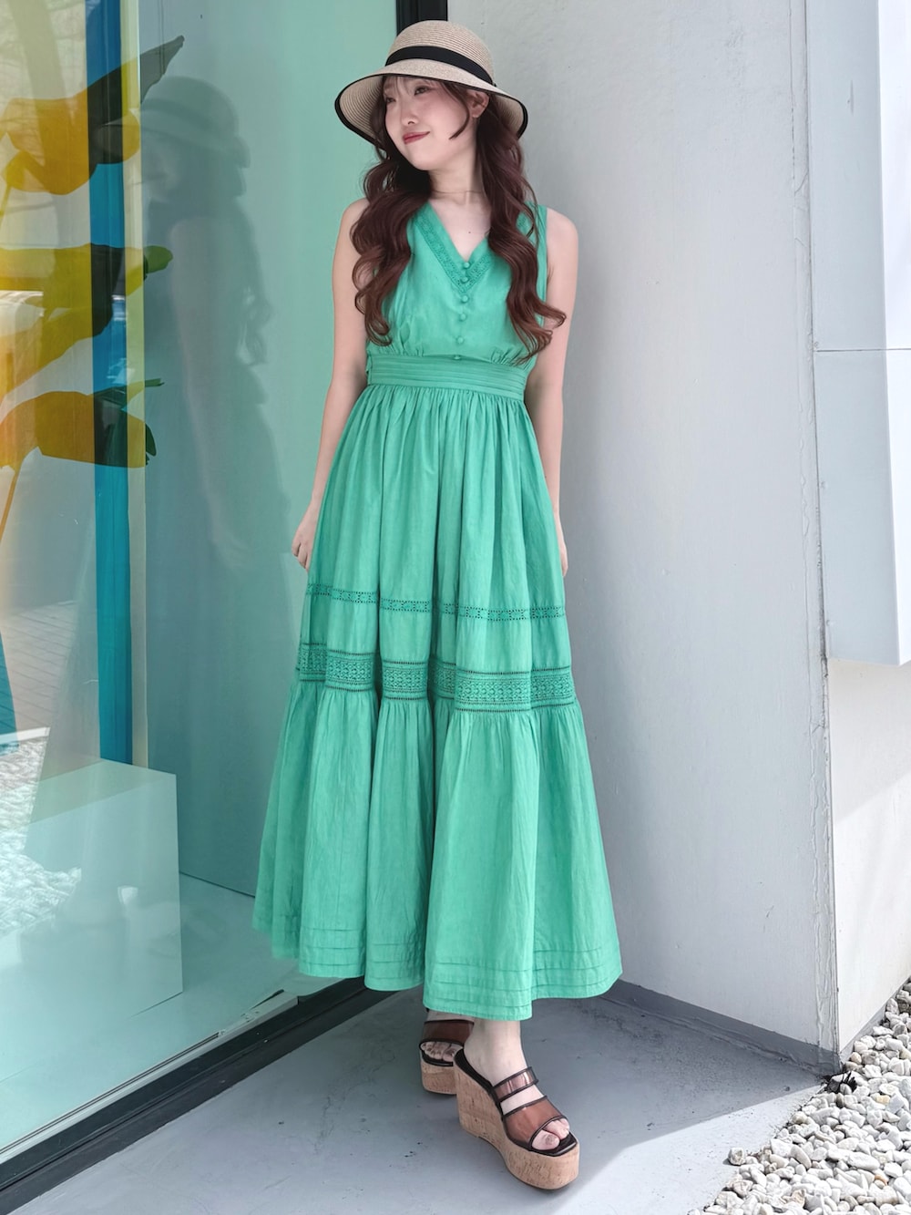 グリーン系のワンピース、ブラウン系のサンダル、ベージュ系のその他雑貨を着用したレディースの春コーディネートの2枚目の写真