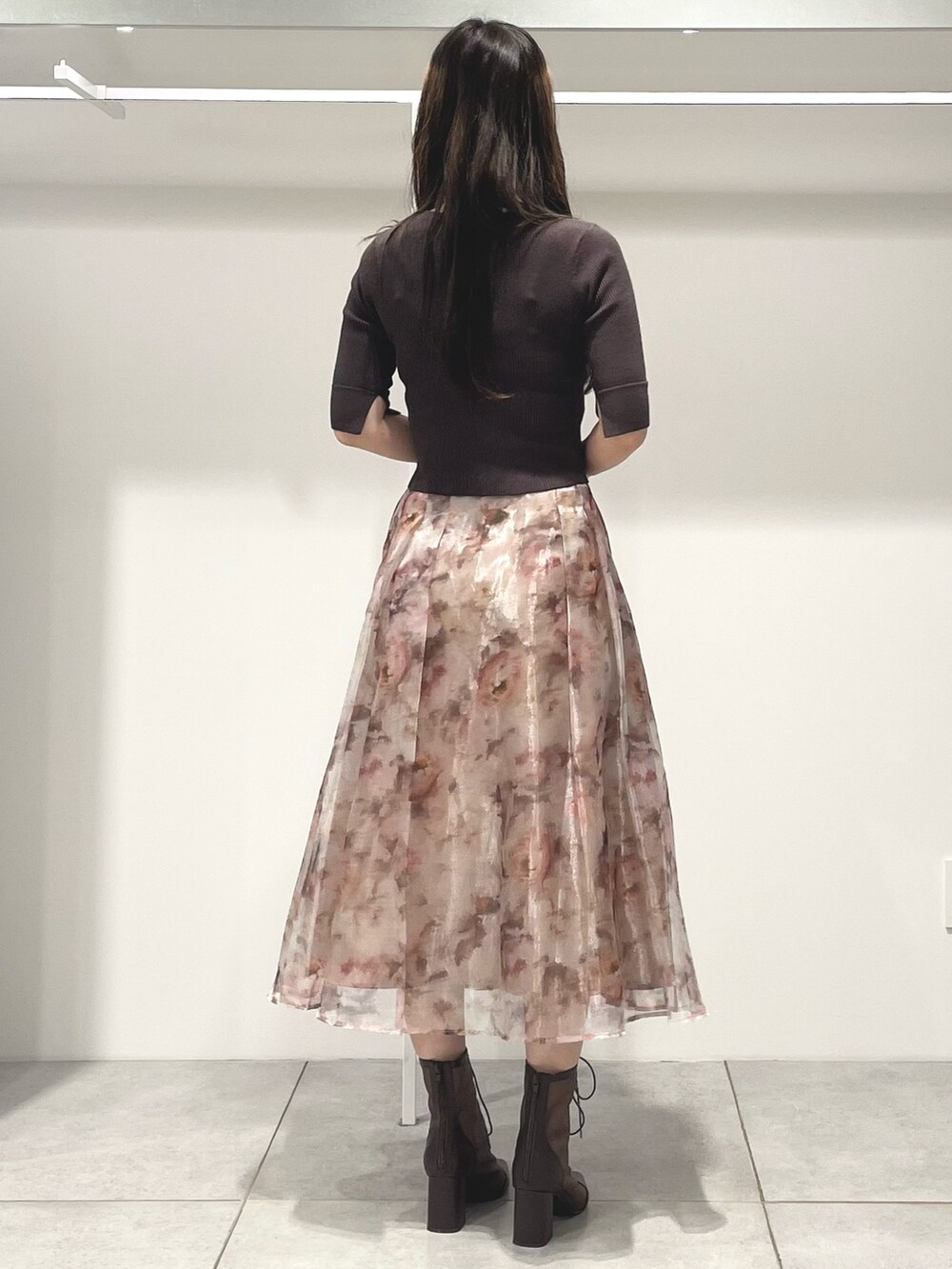 ブラウン系のニット/セーター、ピンク系のスカート、ブラウン系のブーツを着用したレディースの秋コーディネートの4枚目の写真