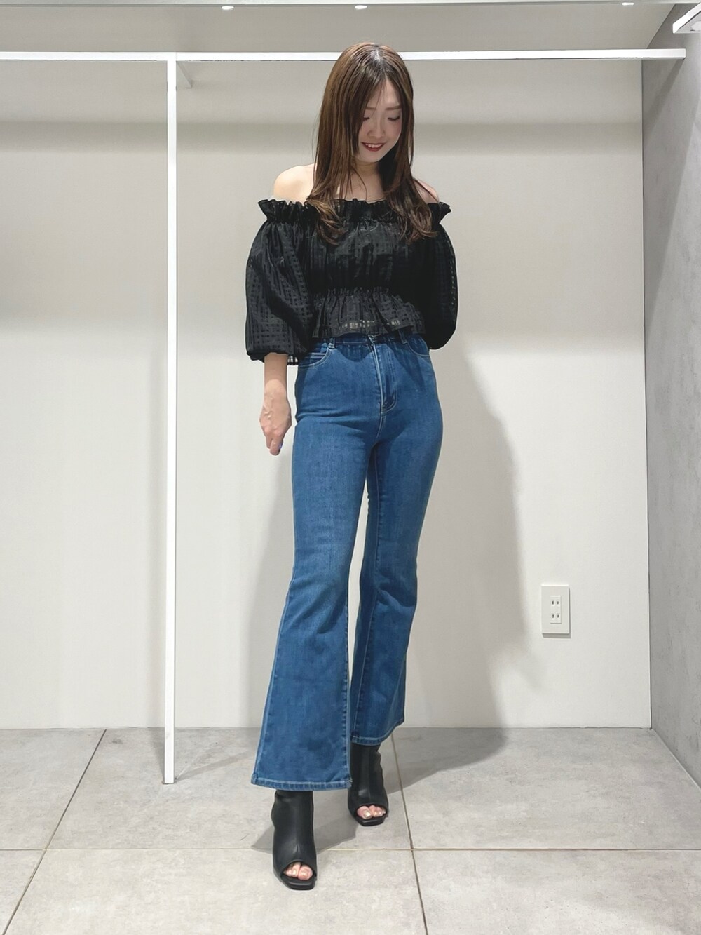 ブルー系のトレンチコート、ブルー系のデニムパンツ、ブラック系のブーツを着用したレディースの春コーディネートの6枚目の写真