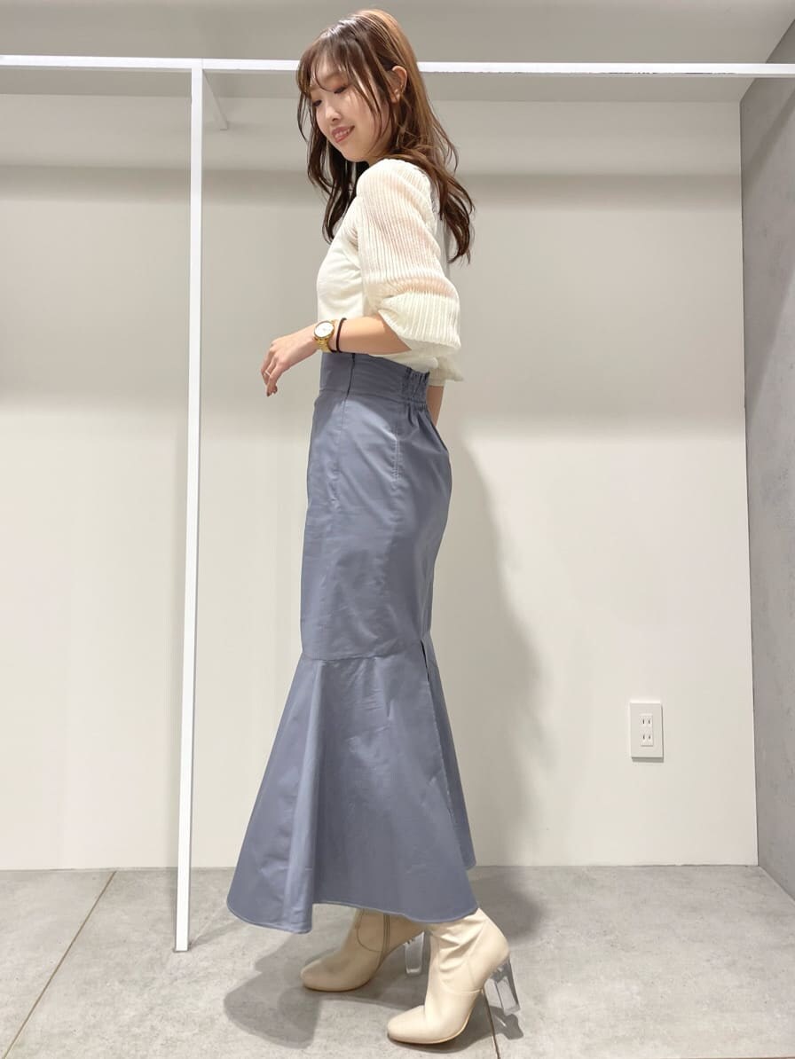 ブルー系のスカート、ホワイト系のニット/セーターを着用したレディースの春コーディネートの2枚目の写真
