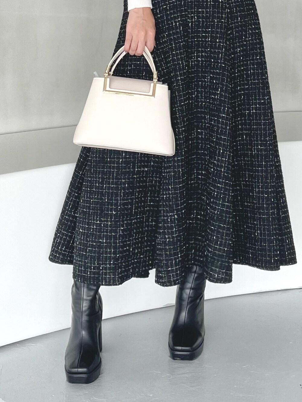 その他のニット/セーター、ブラック系のスカート、ホワイト系のハンドバッグを着用したレディースの秋コーディネートの8枚目の写真