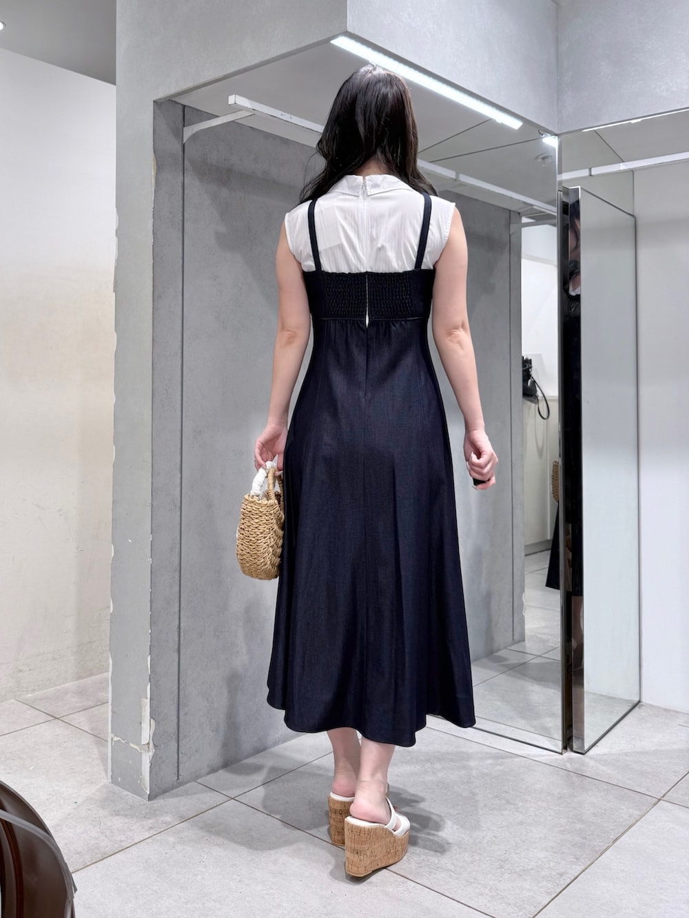 ブルー系のワンピース、ベージュ系のハンドバッグ、ホワイト系のサンダルを着用したレディースの夏コーディネートの3枚目の写真