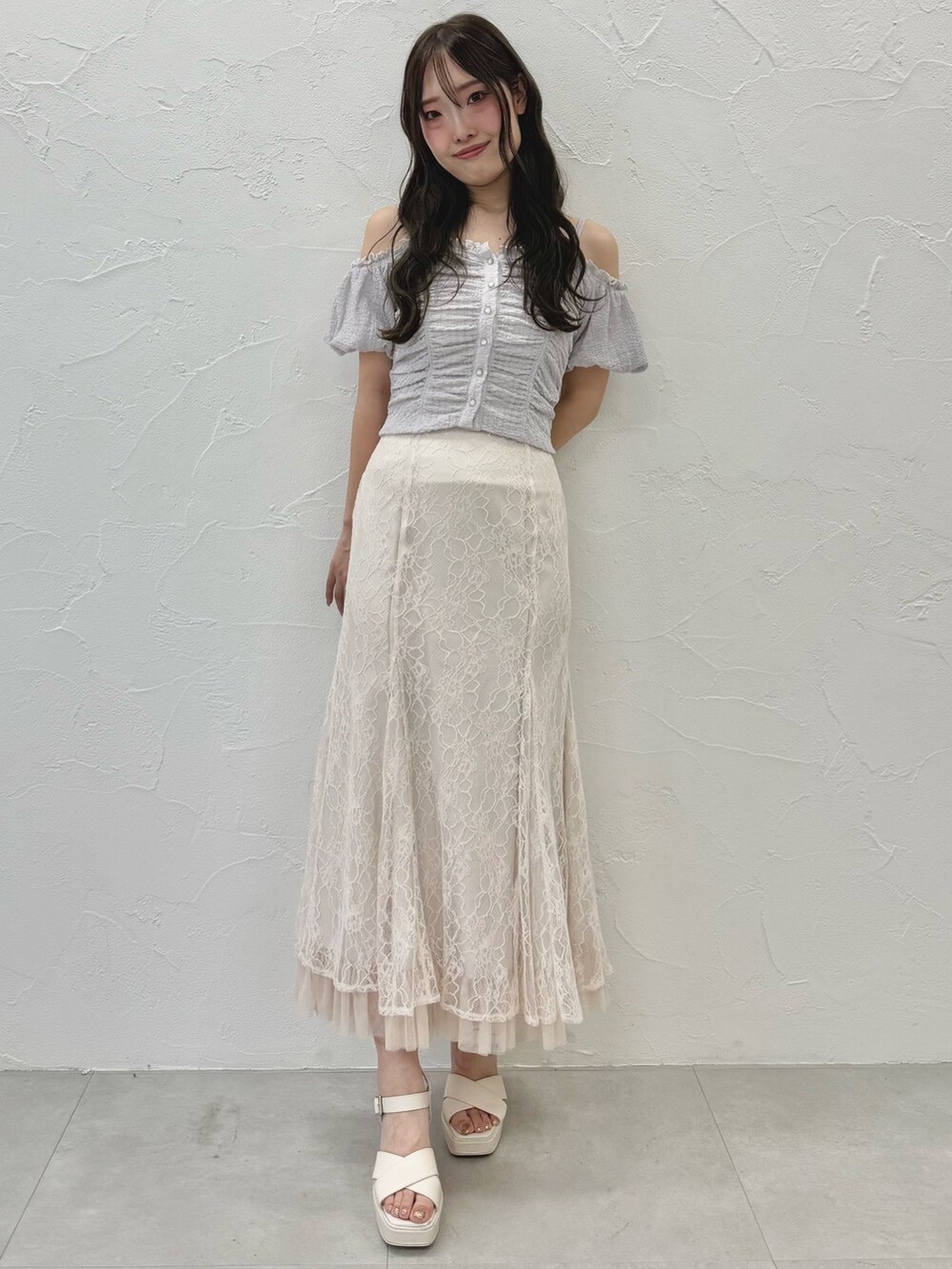 ホワイト系のスカート、ホワイト系のサンダル、パープル系のTシャツ/カットソーを着用したレディースの夏コーディネートの2枚目の写真