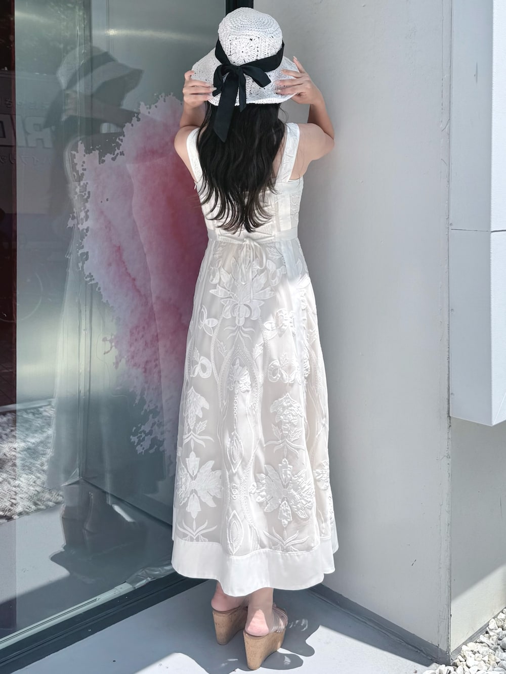 ホワイト系のワンピース、その他のサンダル、ホワイト系のハットを着用したレディースの夏コーディネートの3枚目の写真