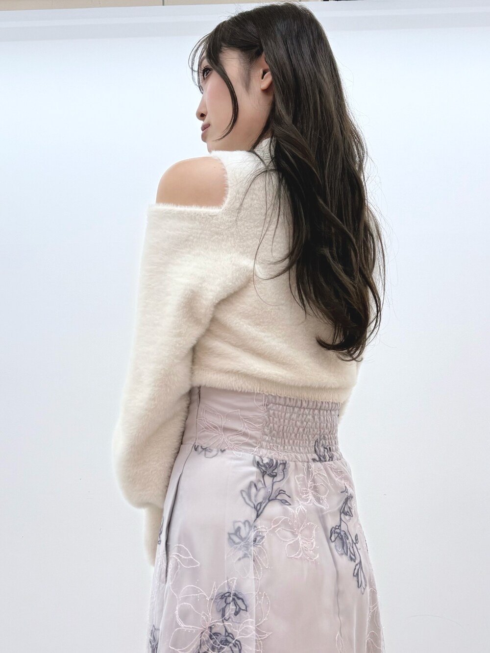 パープル系のスカート、ホワイト系のニット/セーター、ブラック系のブーツを着用したレディースの秋コーディネートの6枚目の写真