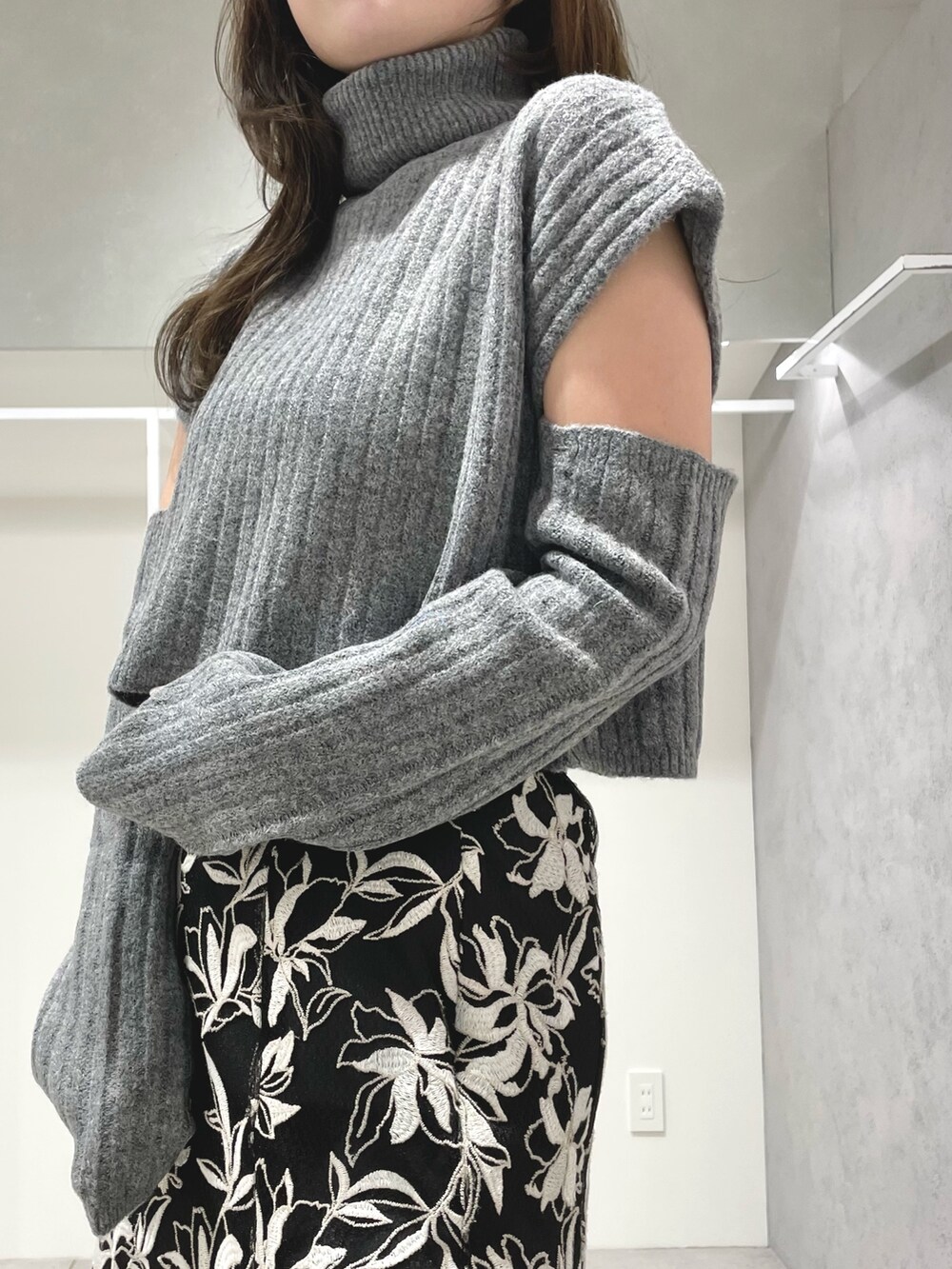 ブラック系のスカート、ブラック系のブーツ、グレー系のニット/セーターを着用したレディースの冬コーディネートの4枚目の写真