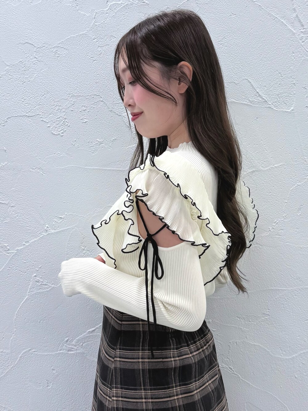 グレー系のスカート、ブラック系のブーツ、ホワイト系のニット/セーターを着用したレディースの秋コーディネートの5枚目の写真