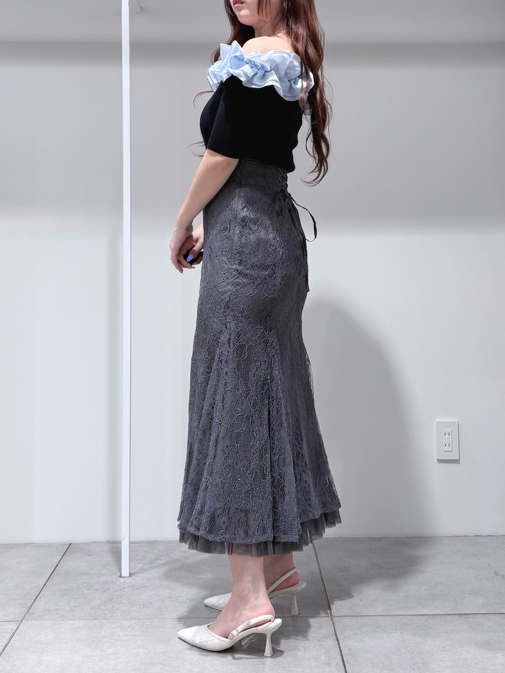 ブルー系のニット/セーター、グレー系のスカート、ホワイト系のパンプスを着用したレディースの春コーディネートの2枚目の写真