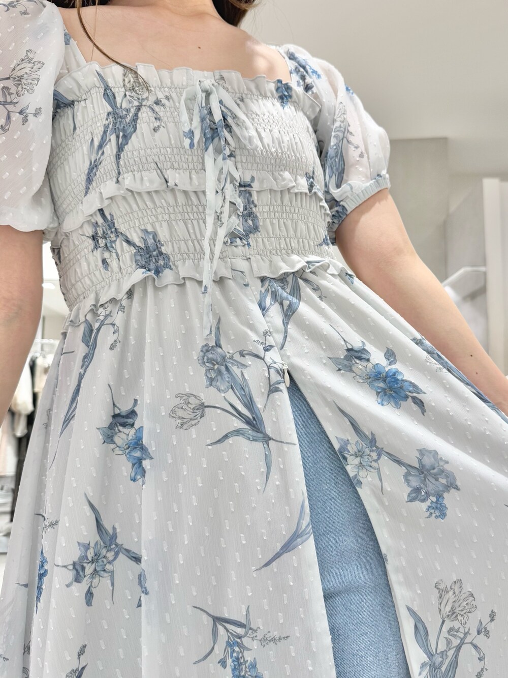 グレー系のワンピース、ブルー系のデニムパンツ、その他のサンダルを着用したレディースの春コーディネートの6枚目の写真