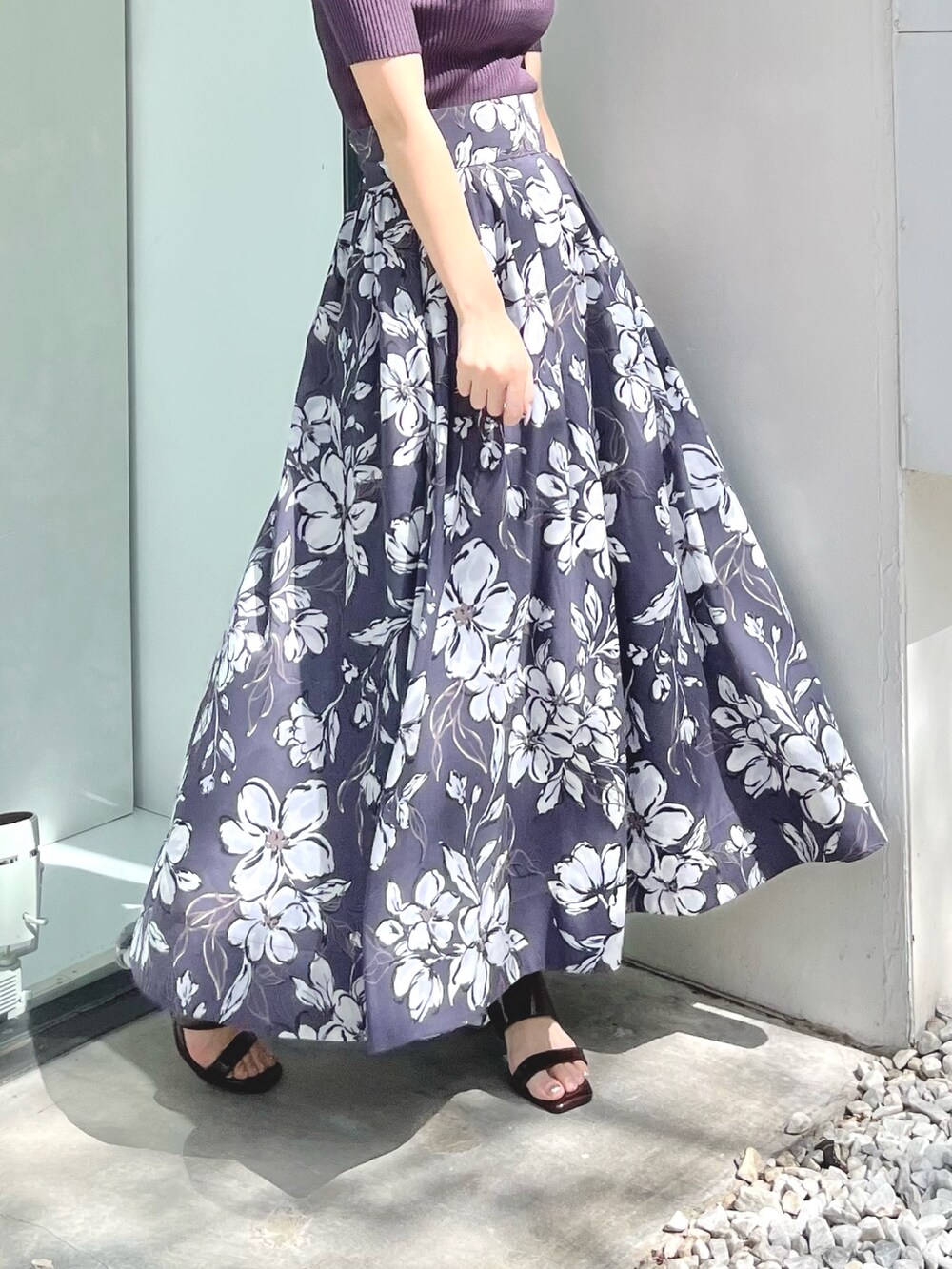 パープル系のスカート、ブラウン系のサンダル、パープル系のニット/セーターを着用したレディースの春コーディネートの4枚目の写真