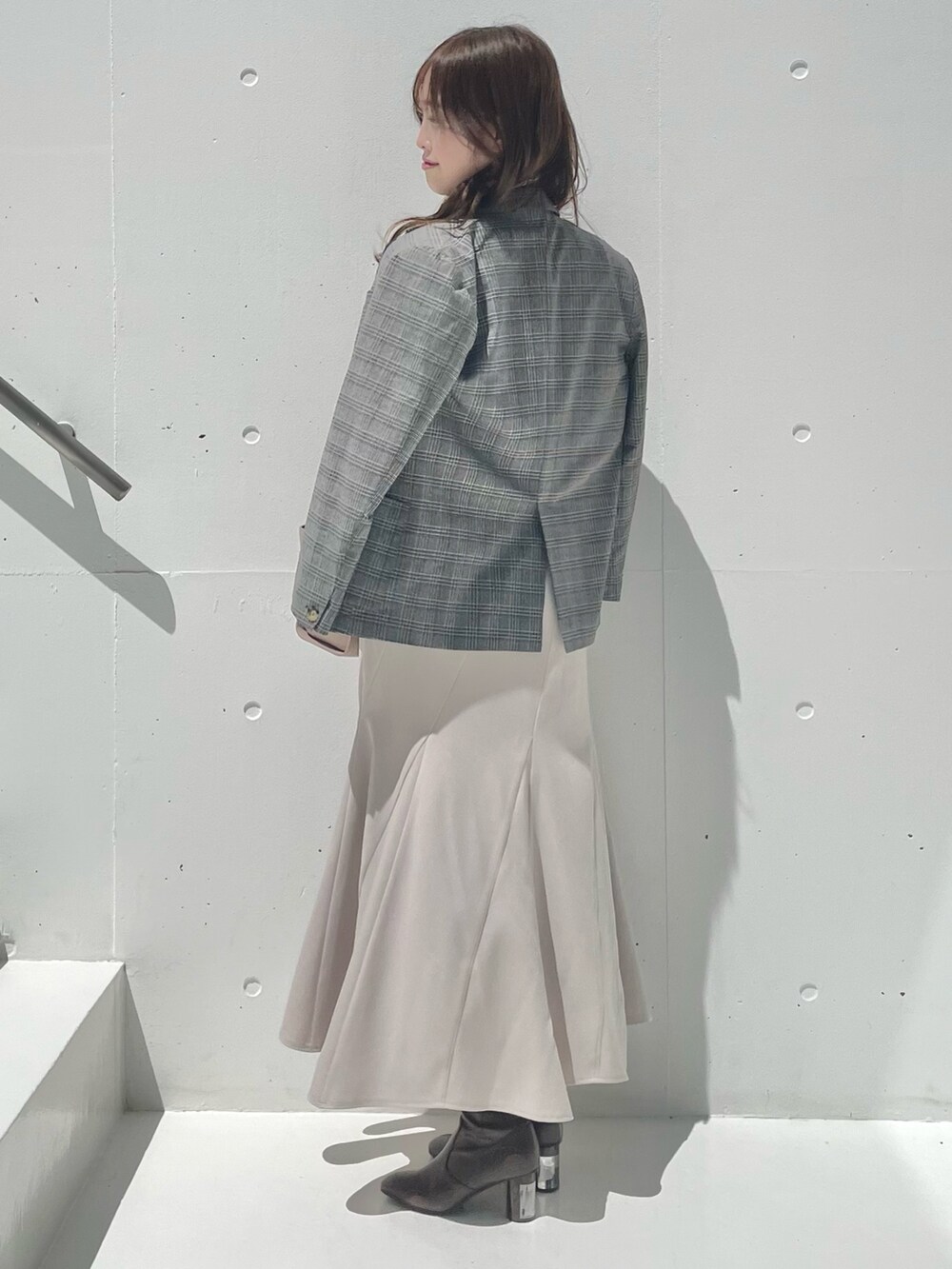 グレー系のテーラードジャケット、ベージュ系のシャツ/ブラウス、ベージュ系のスカートを着用したレディースの秋コーディネートの2枚目の写真