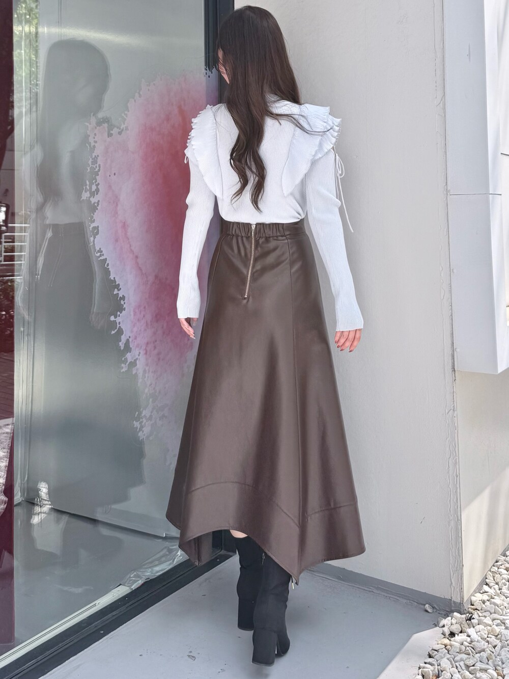 ブラウン系のスカート、ブルー系のニット/セーター、ブラック系のブーツを着用したレディースの秋コーディネートの4枚目の写真