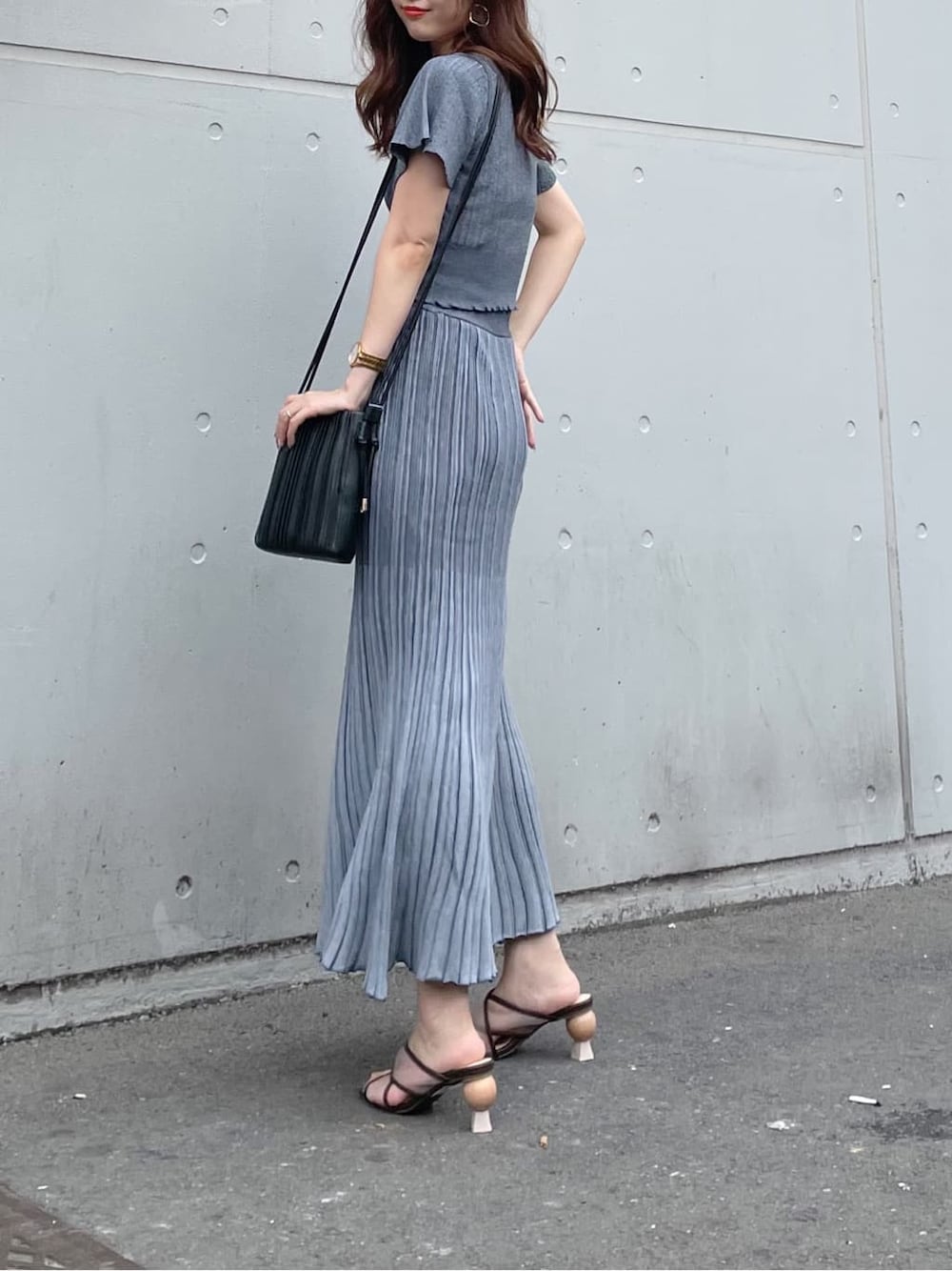 ブラウン系のサンダル、ブルー系のワンピース、ベージュ系のショルダーバッグを着用したレディースの夏コーディネートの2枚目の写真