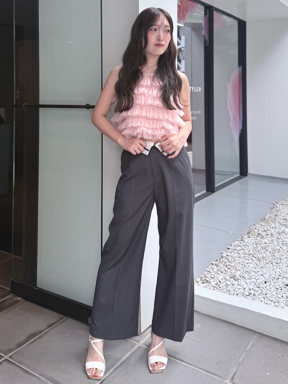 ピンク系のシャツ/ブラウス、グレー系のその他パンツ、ホワイト系のサンダルを着用したレディースの夏コーディネートの2枚目の写真