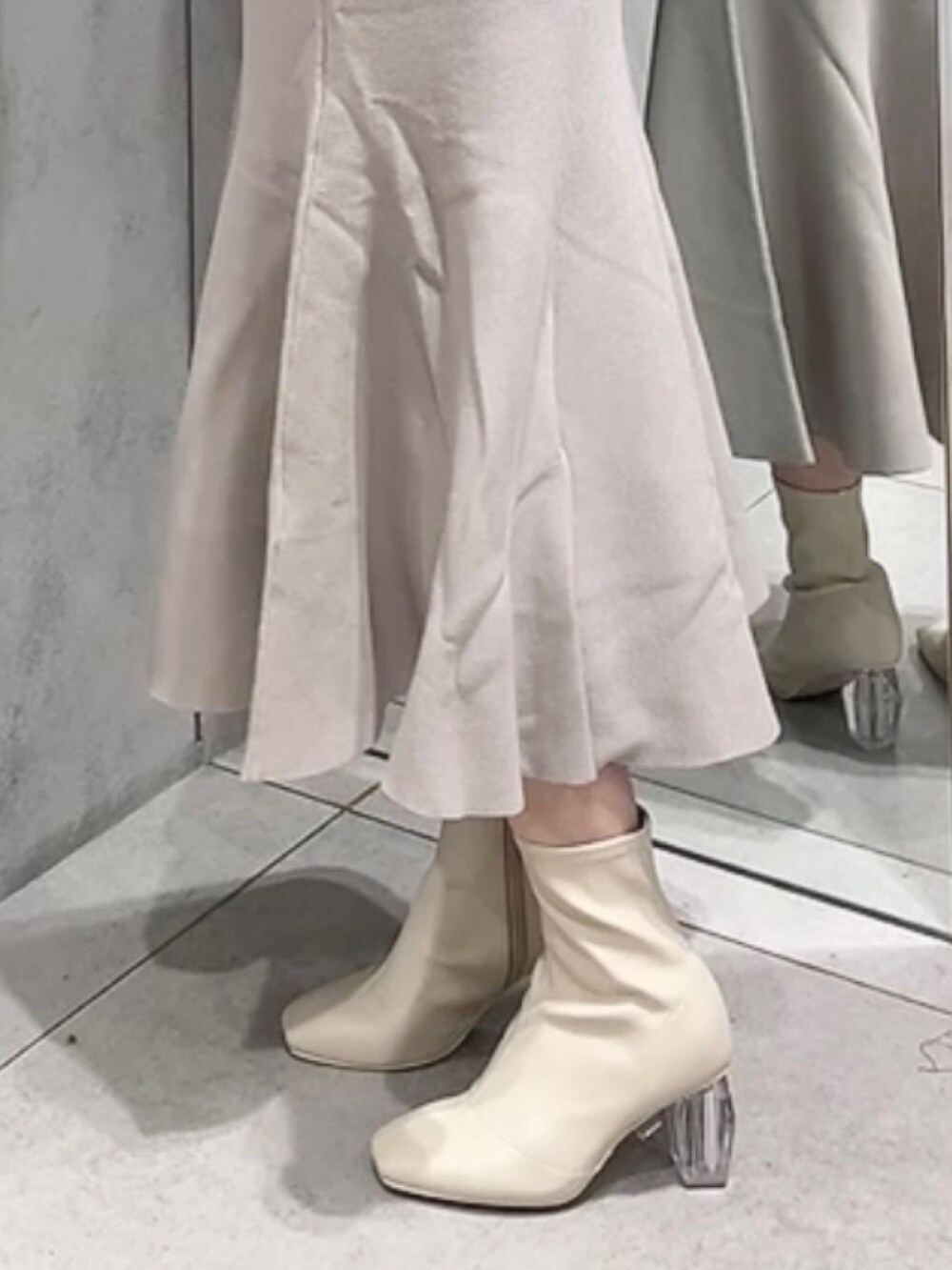 ベージュ系のワンピース、ホワイト系のブーツを着用したレディースの秋コーディネートの7枚目の写真