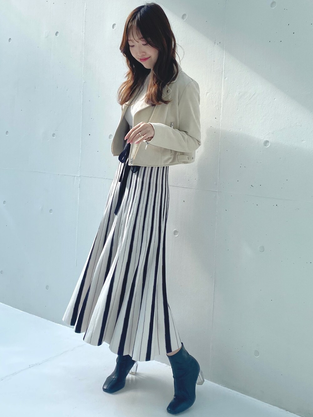 ホワイト系のワンピース、ベージュ系のライダースジャケットを着用したレディースの春コーディネートの3枚目の写真