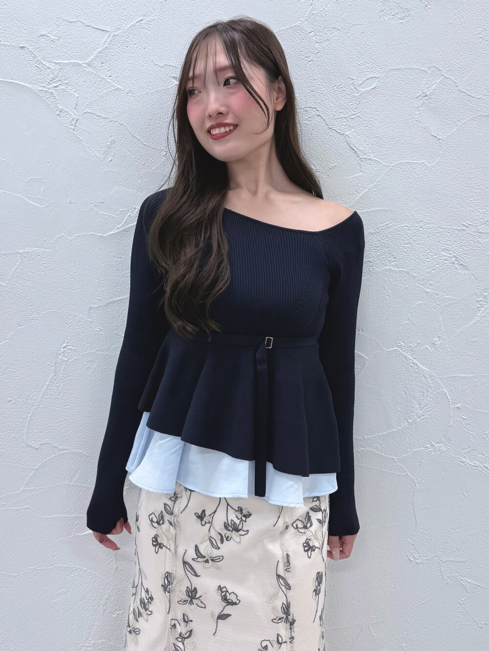 ブルー系のニット/セーター、ホワイト系のスカート、ブラック系のブーツを着用したレディースの秋コーディネートの4枚目の写真