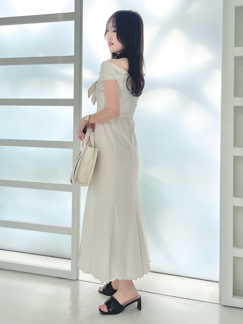 ホワイト系のワンピース、ブラウン系のサンダル、ホワイト系のハンドバッグを着用したレディースの春コーディネートの3枚目の写真