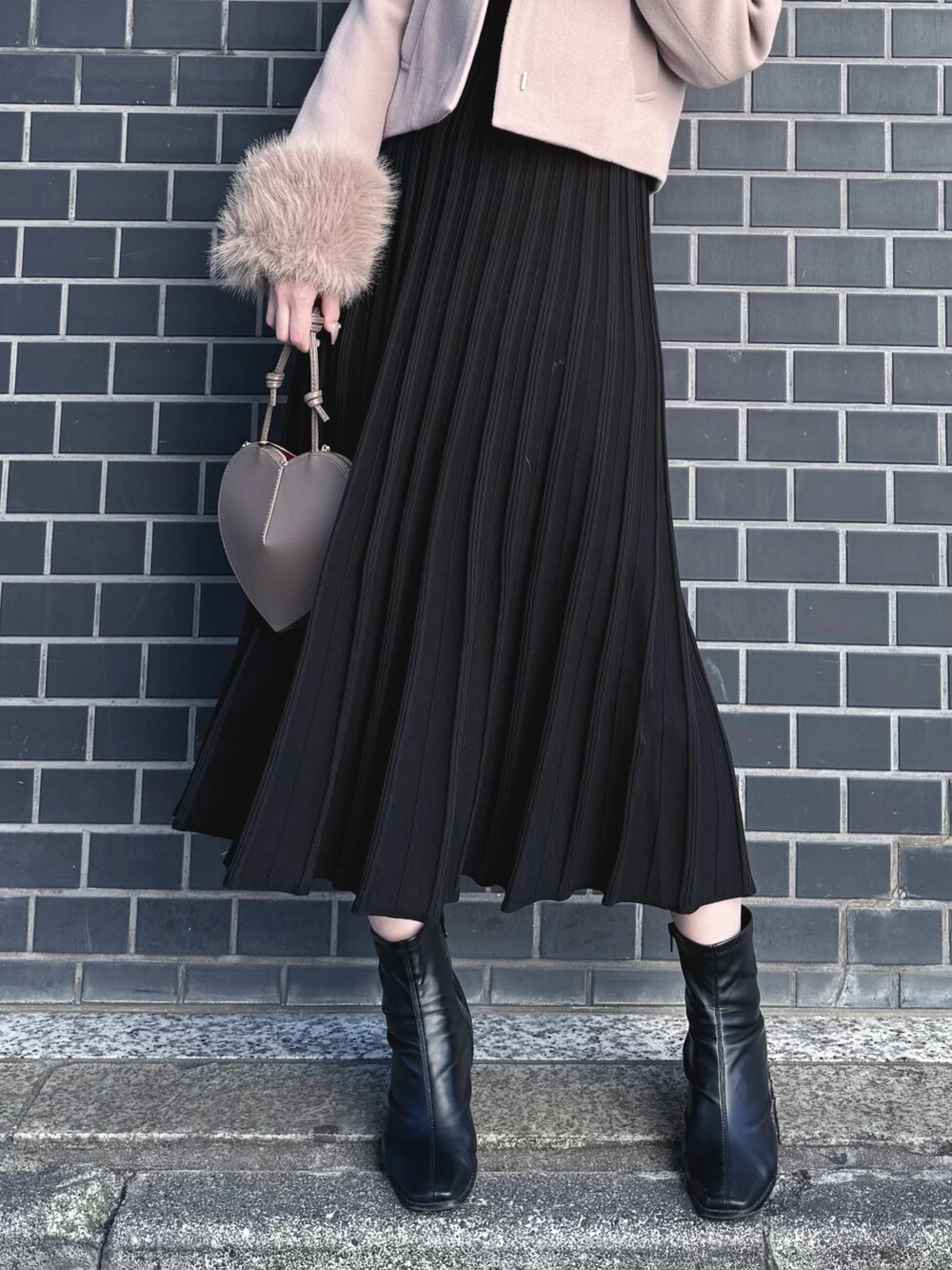 ブラック系のブーツ、ブラック系のワンピース、ベージュ系のショルダーバッグを着用したレディースの冬コーディネートの8枚目の写真