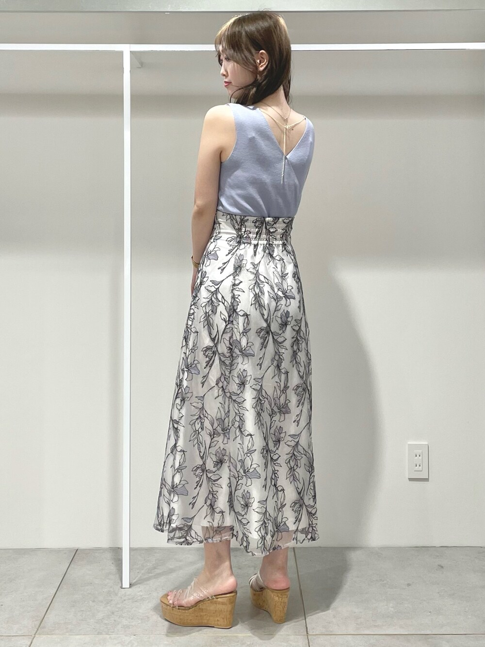 ブルー系のニット/セーター、グレー系のスカート、その他のサンダルを着用したレディースの春コーディネートの4枚目の写真