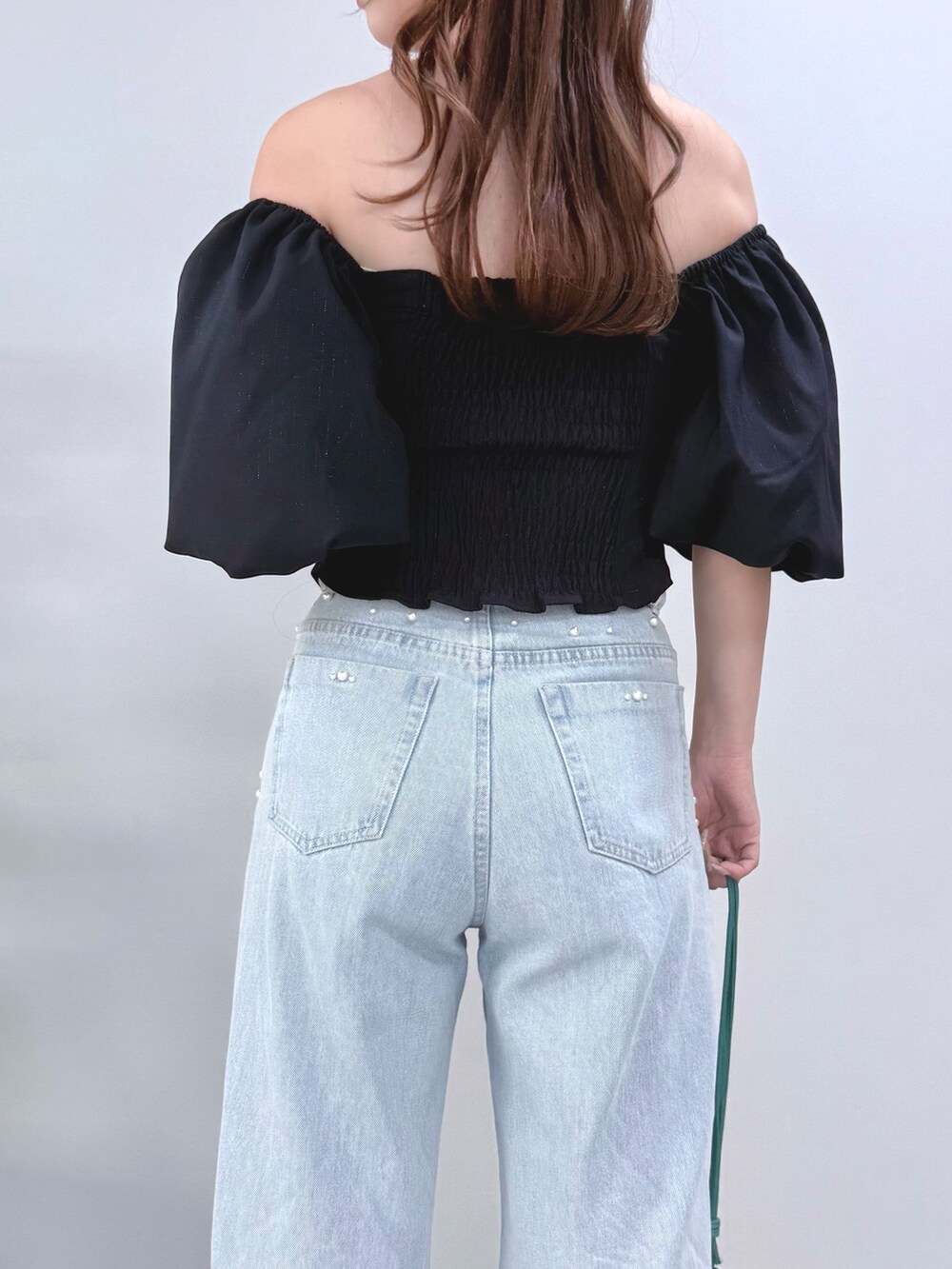 ブルー系のデニムパンツ、グリーン系のショルダーバッグ、ブラック系のサンダルを着用したレディースの夏コーディネートの7枚目の写真