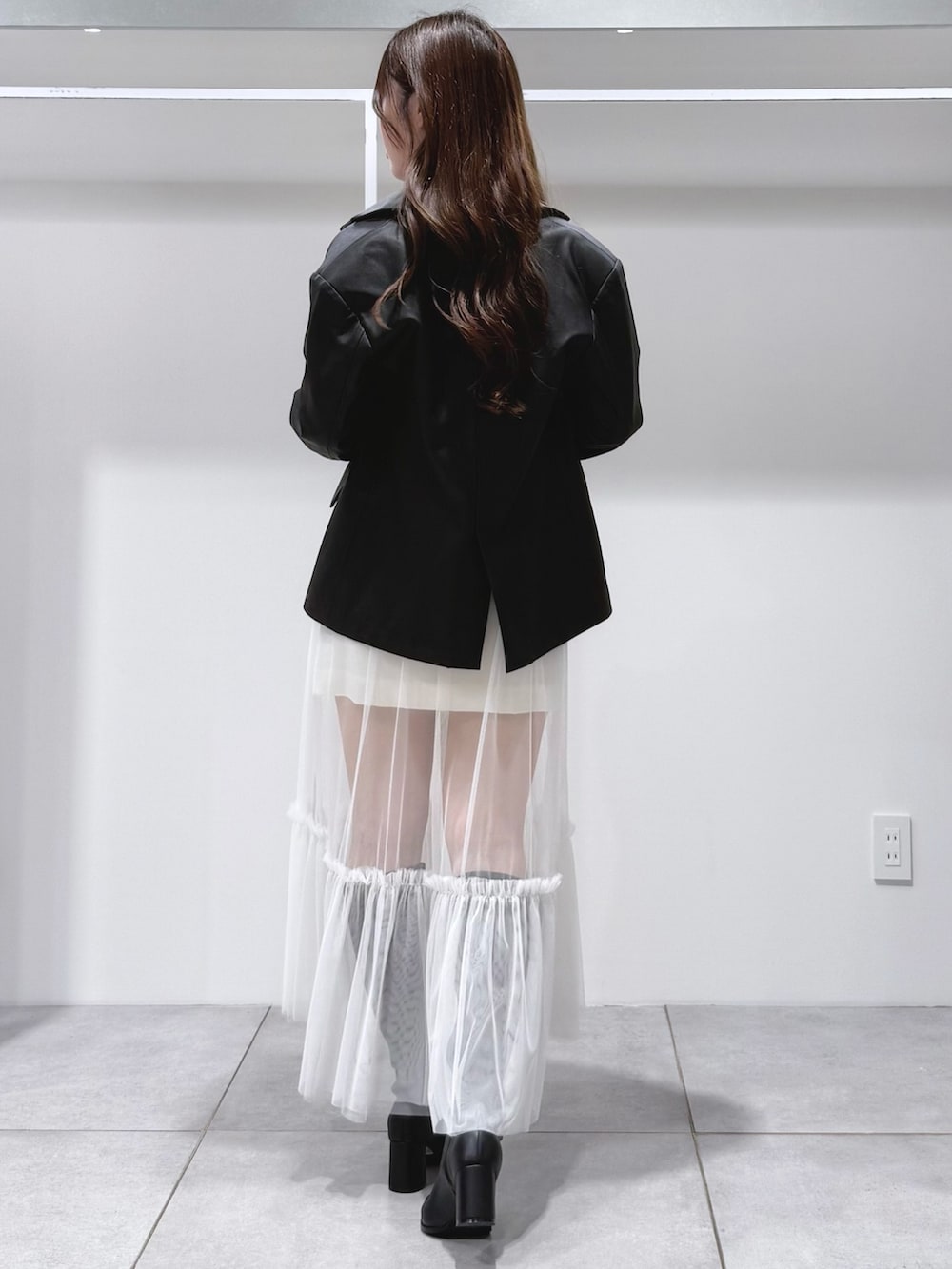 ブラック系のテーラードジャケット、ブラック系のTシャツ/カットソー、ブラック系のブーツを着用したレディースの秋コーディネートの4枚目の写真