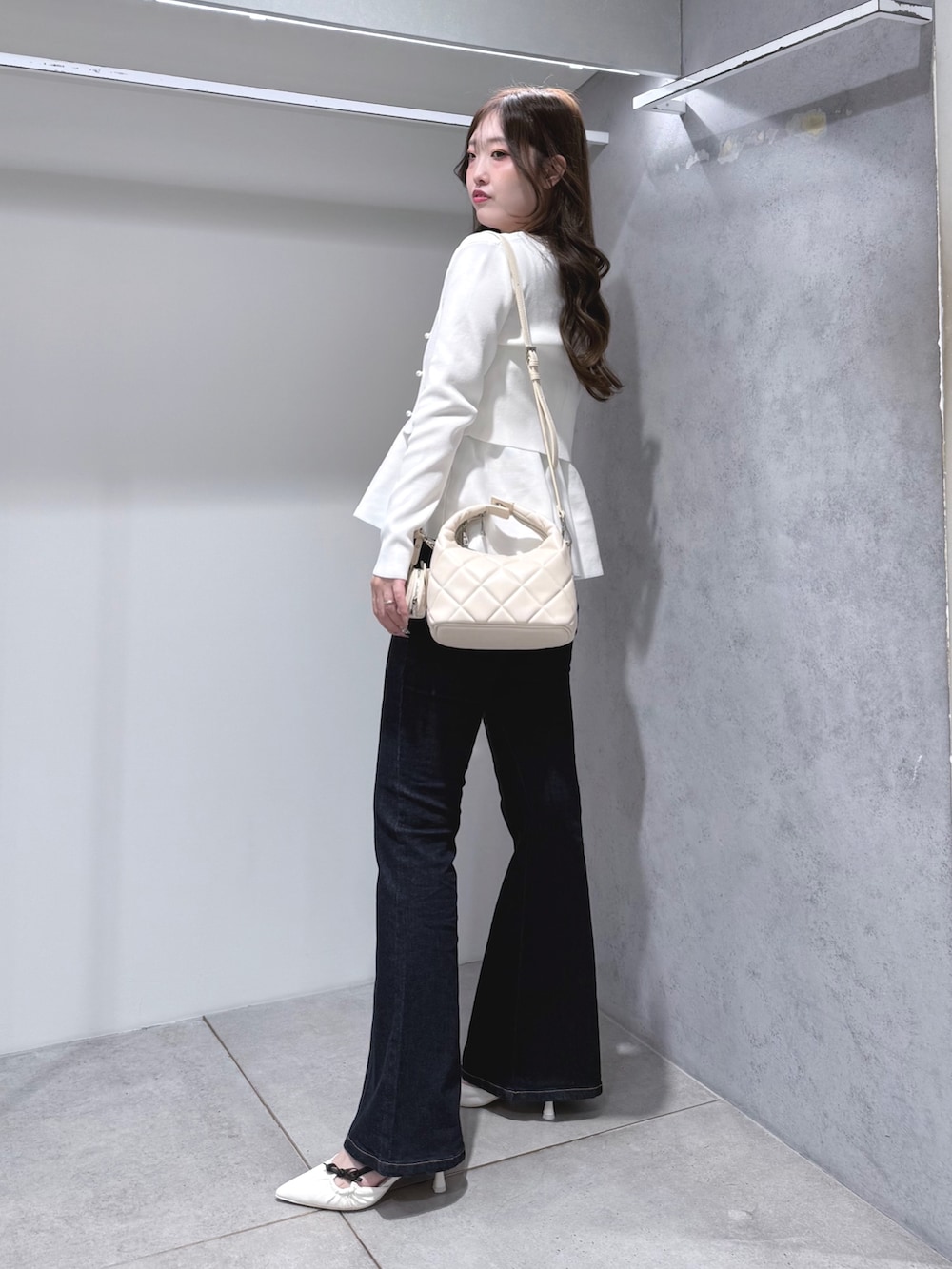 ホワイト系のニット/セーター、ブルー系のその他パンツ、ホワイト系のハンドバッグを着用したレディースの秋コーディネートの3枚目の写真