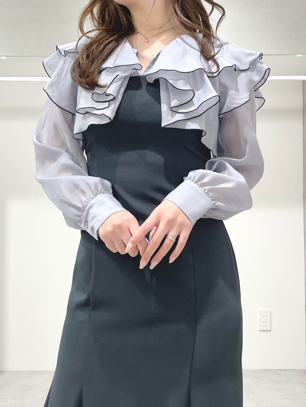 グレー系のワンピース、ホワイト系のブーツ、ホワイト系のハンドバッグを着用したレディースの冬コーディネートの5枚目の写真