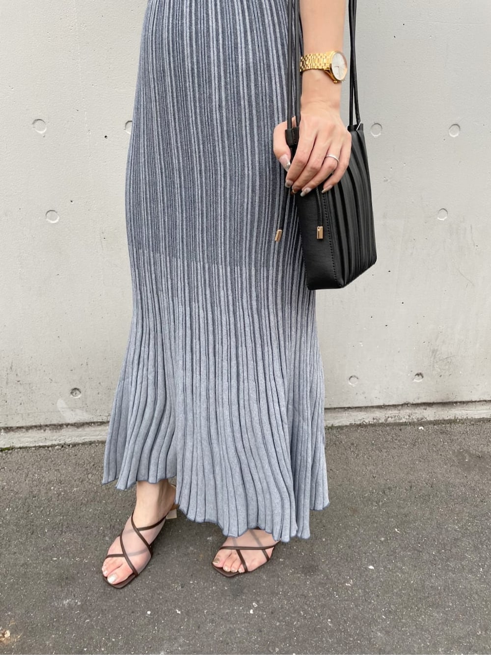 ブラウン系のサンダル、ブルー系のワンピース、ベージュ系のショルダーバッグを着用したレディースの夏コーディネートの4枚目の写真