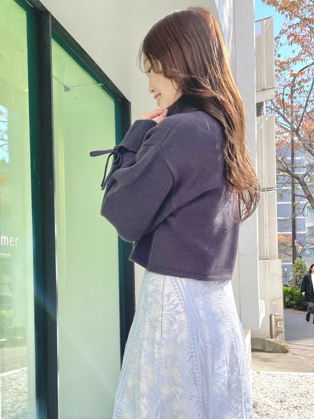 ブルー系のスカート、グレー系のニット/セーター、ブラック系のブーツを着用したレディースの冬コーディネートの7枚目の写真