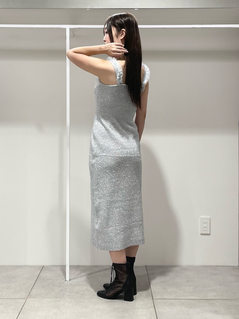 シルバー系のワンピース、ブラック系のショルダーバッグ、ブラック系のブーツを着用したレディースの秋コーディネートの8枚目の写真