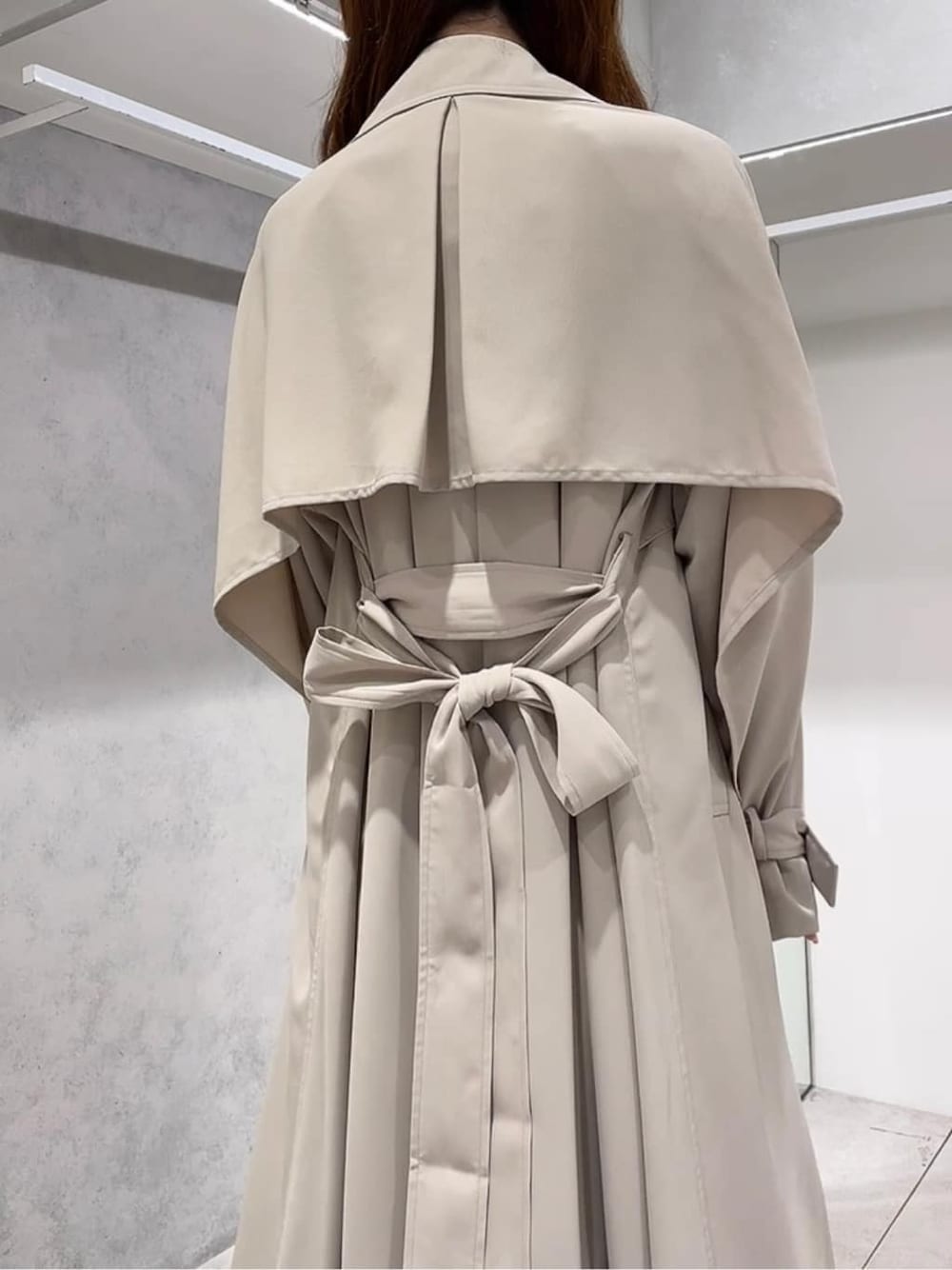 ベージュ系のトレンチコート、ベージュ系のトレンチコート、ホワイト系のワンピースを着用したレディースの秋コーディネートの4枚目の写真