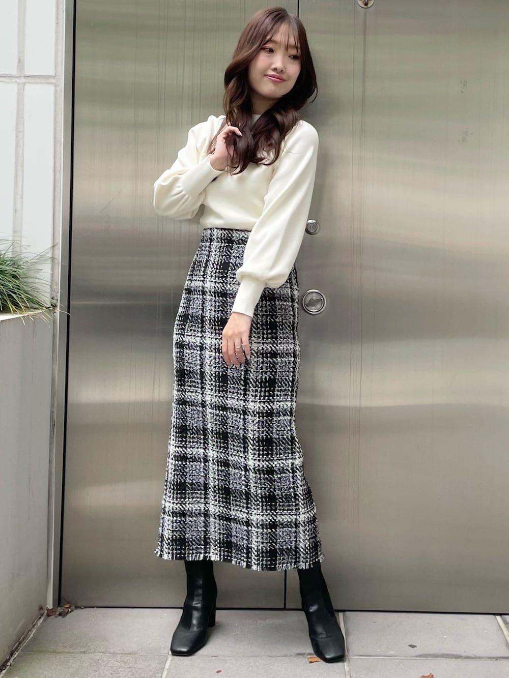 グリーン系のカーディガン/ボレロ、ブラック系のスカート、ブラック系のブーツを着用したレディースの秋コーディネートの6枚目の写真