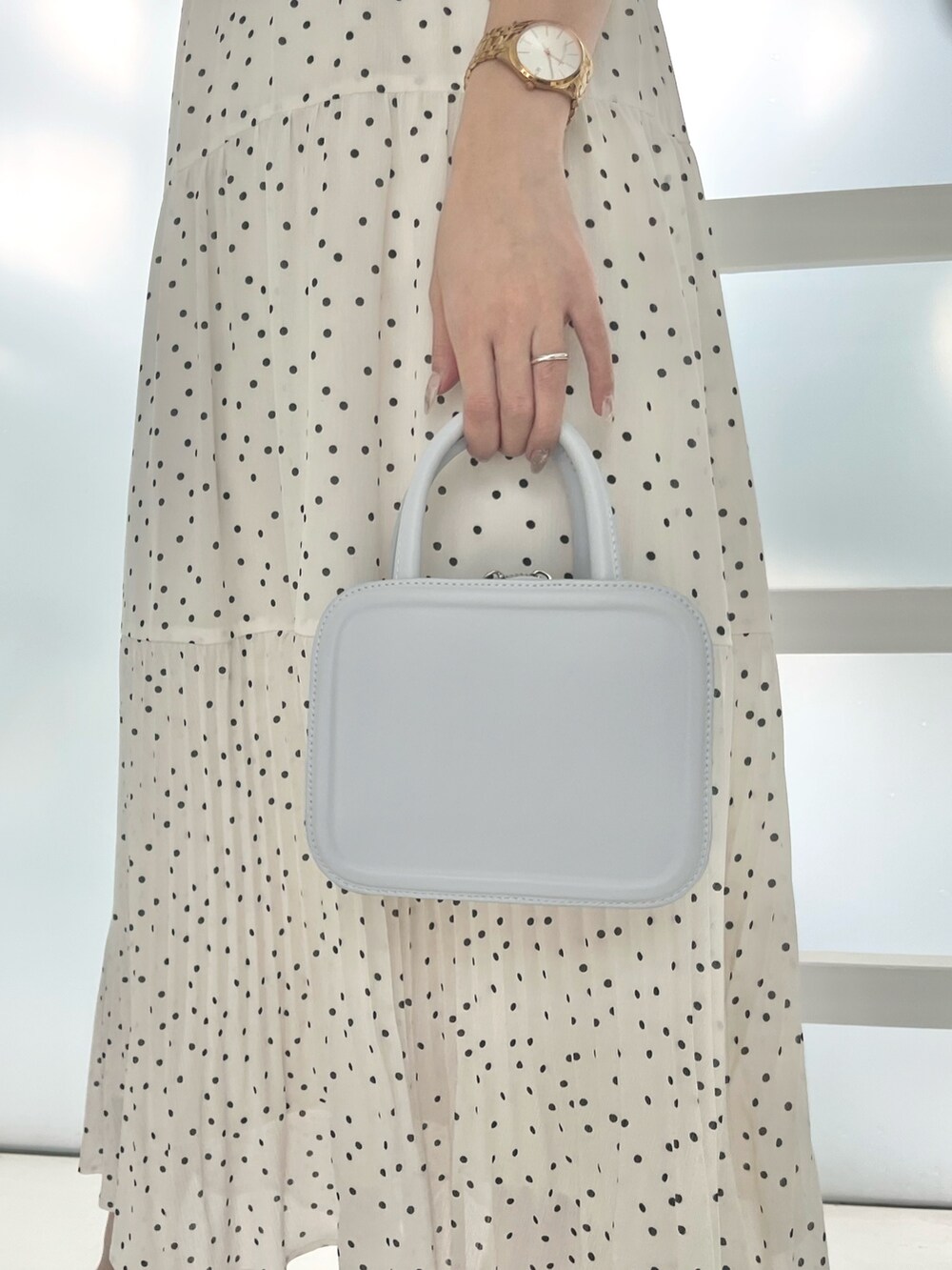 ホワイト系のワンピース、ブルー系のハンドバッグ、ホワイト系のサンダルを着用したレディースの夏コーディネートの4枚目の写真