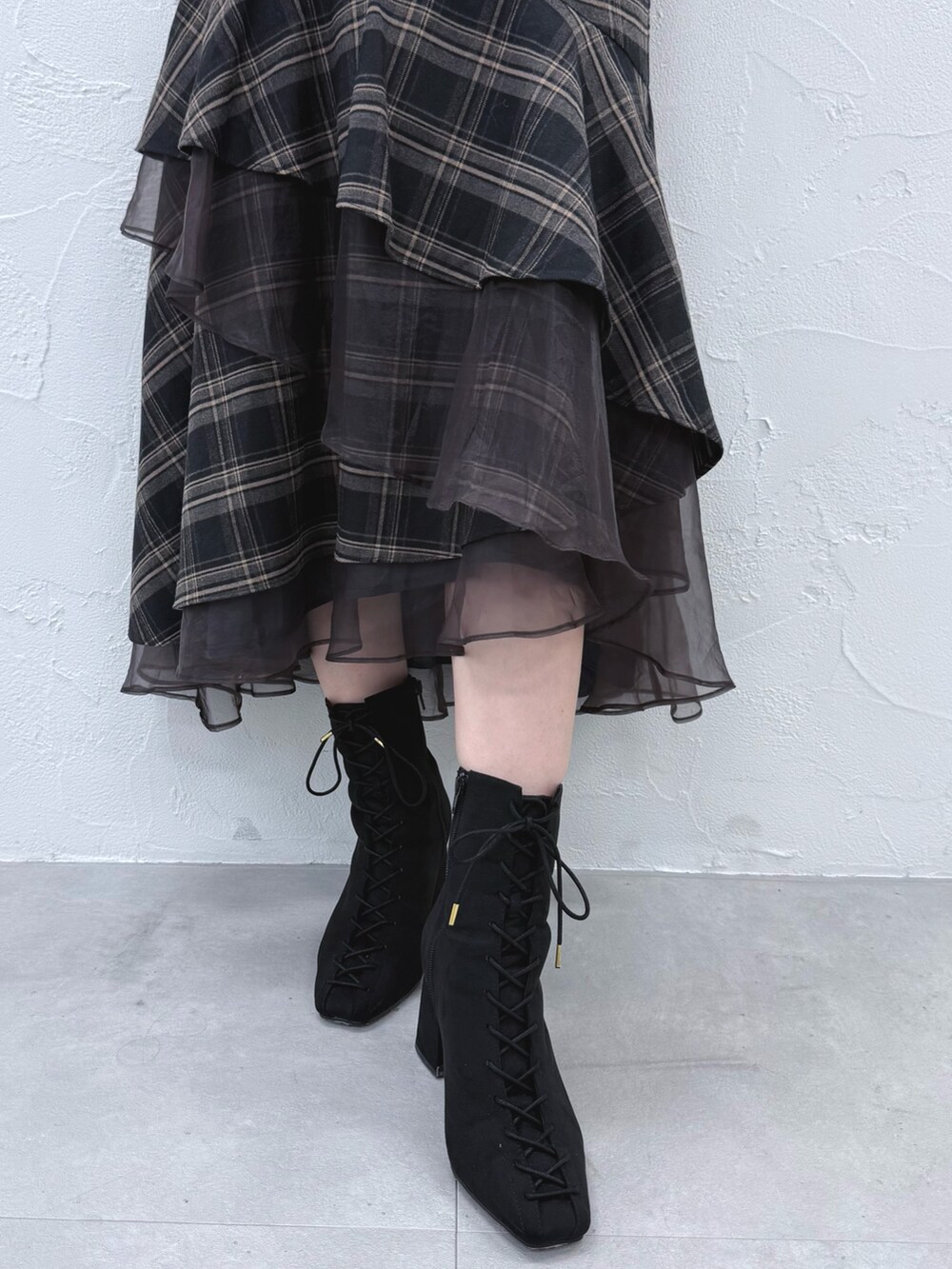 グレー系のスカート、ブラック系のブーツ、ホワイト系のニット/セーターを着用したレディースの秋コーディネートの7枚目の写真