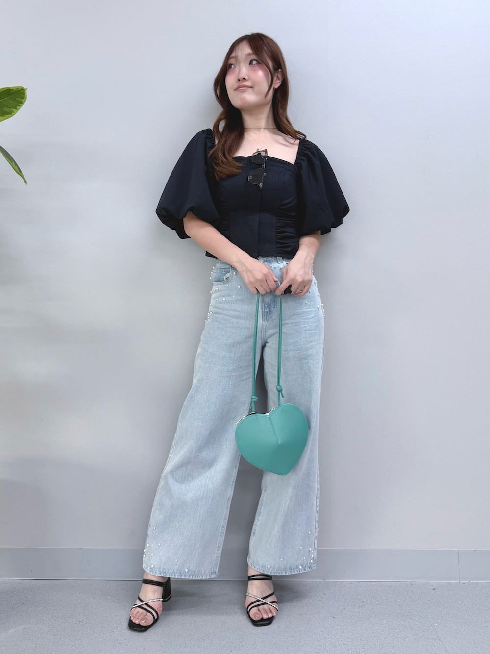 ブルー系のデニムパンツ、グリーン系のショルダーバッグ、ブラック系のサンダルを着用したレディースの夏コーディネートの4枚目の写真