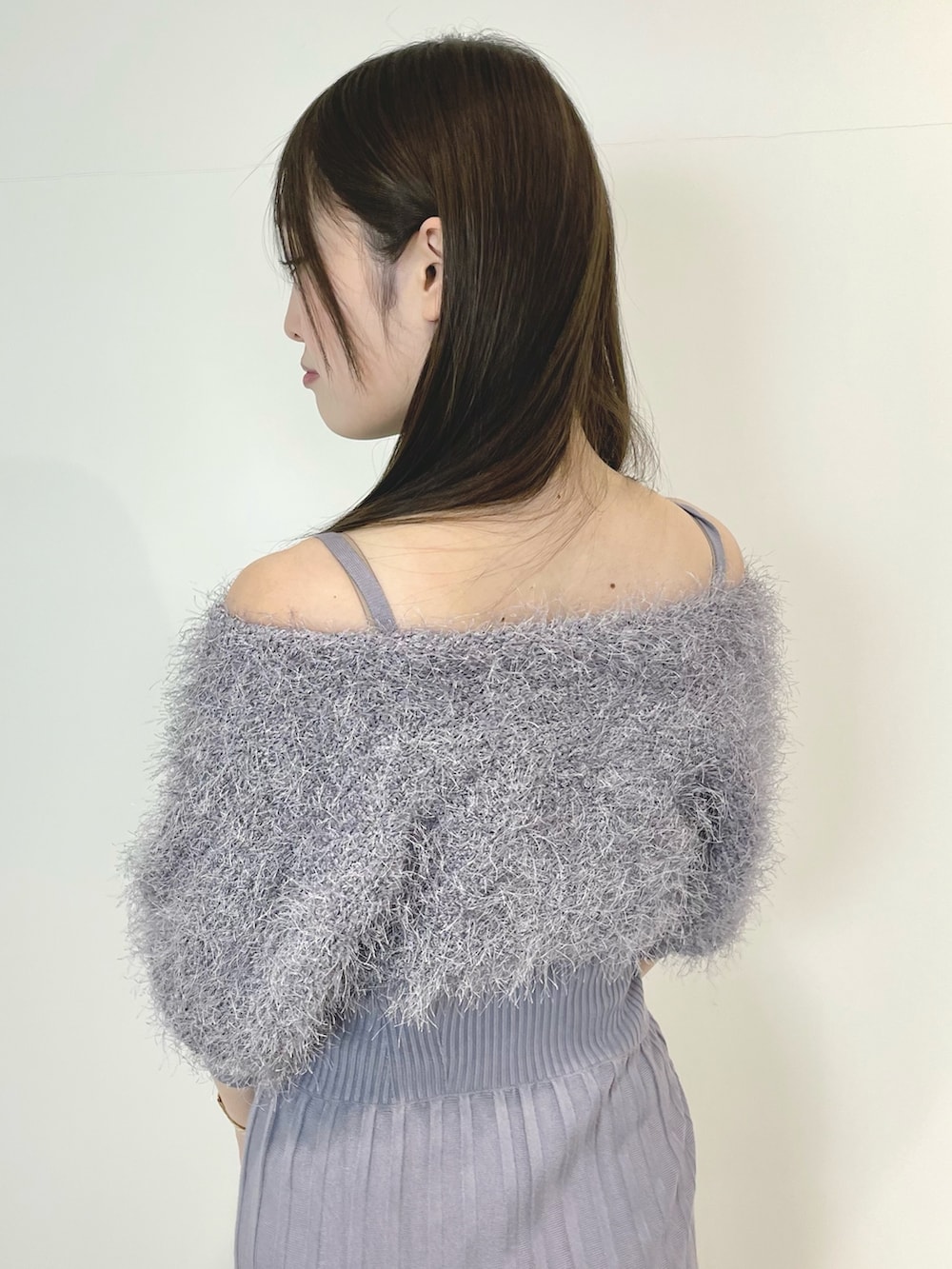 ブルー系のワンピース、シルバー系のハンドバッグ、シルバー系のブーツを着用したレディースの冬コーディネートの5枚目の写真