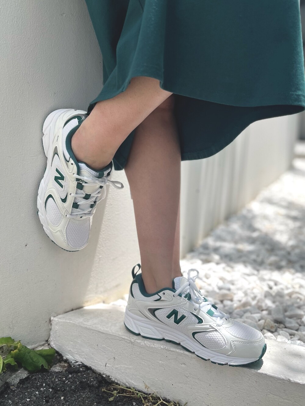 グリーン系のワンピース、グリーン系のスニーカー、ベージュ系のキャップを着用したレディースの夏コーディネートの3枚目の写真